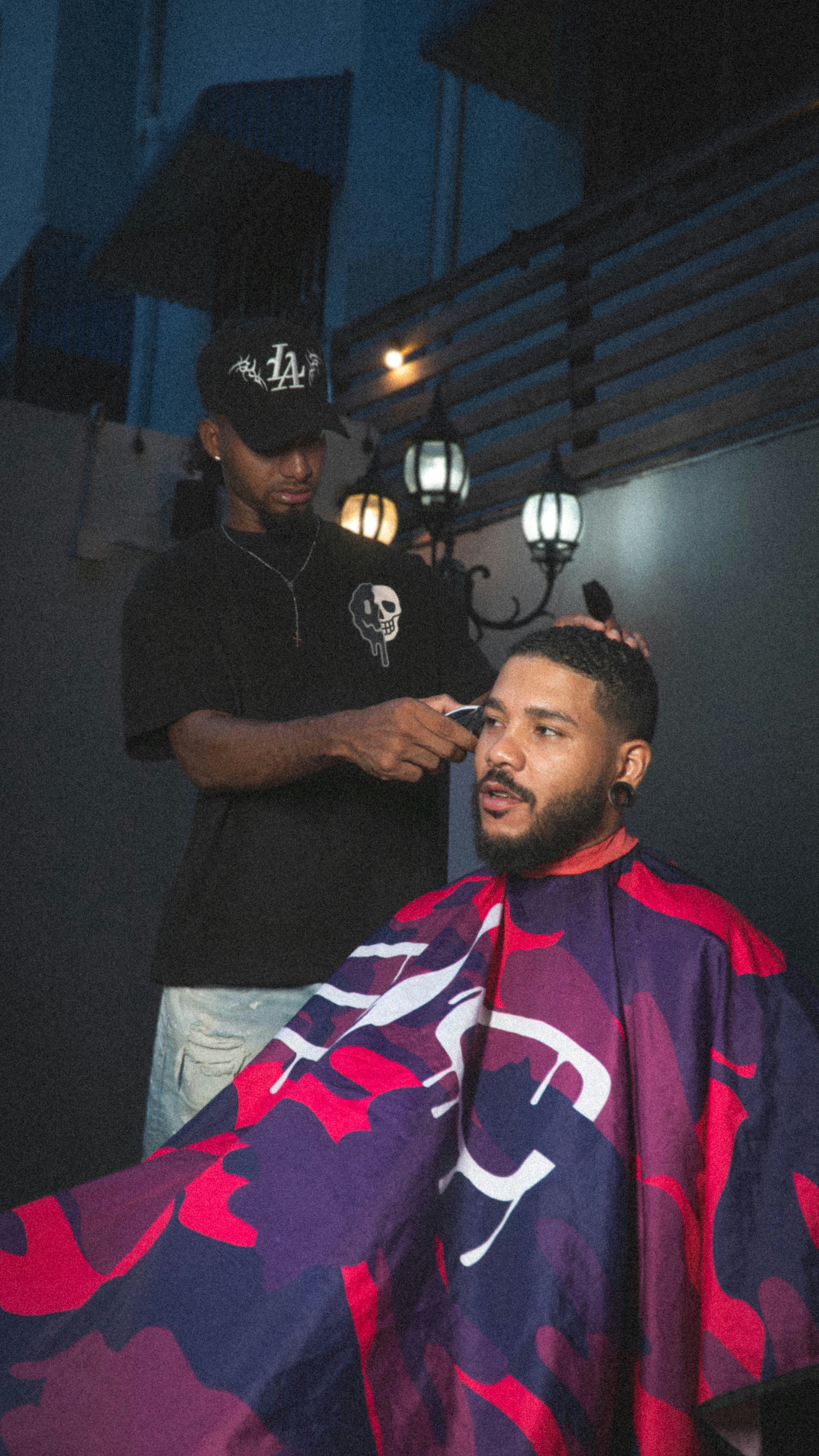 Barber cutting client's hair with clippers.