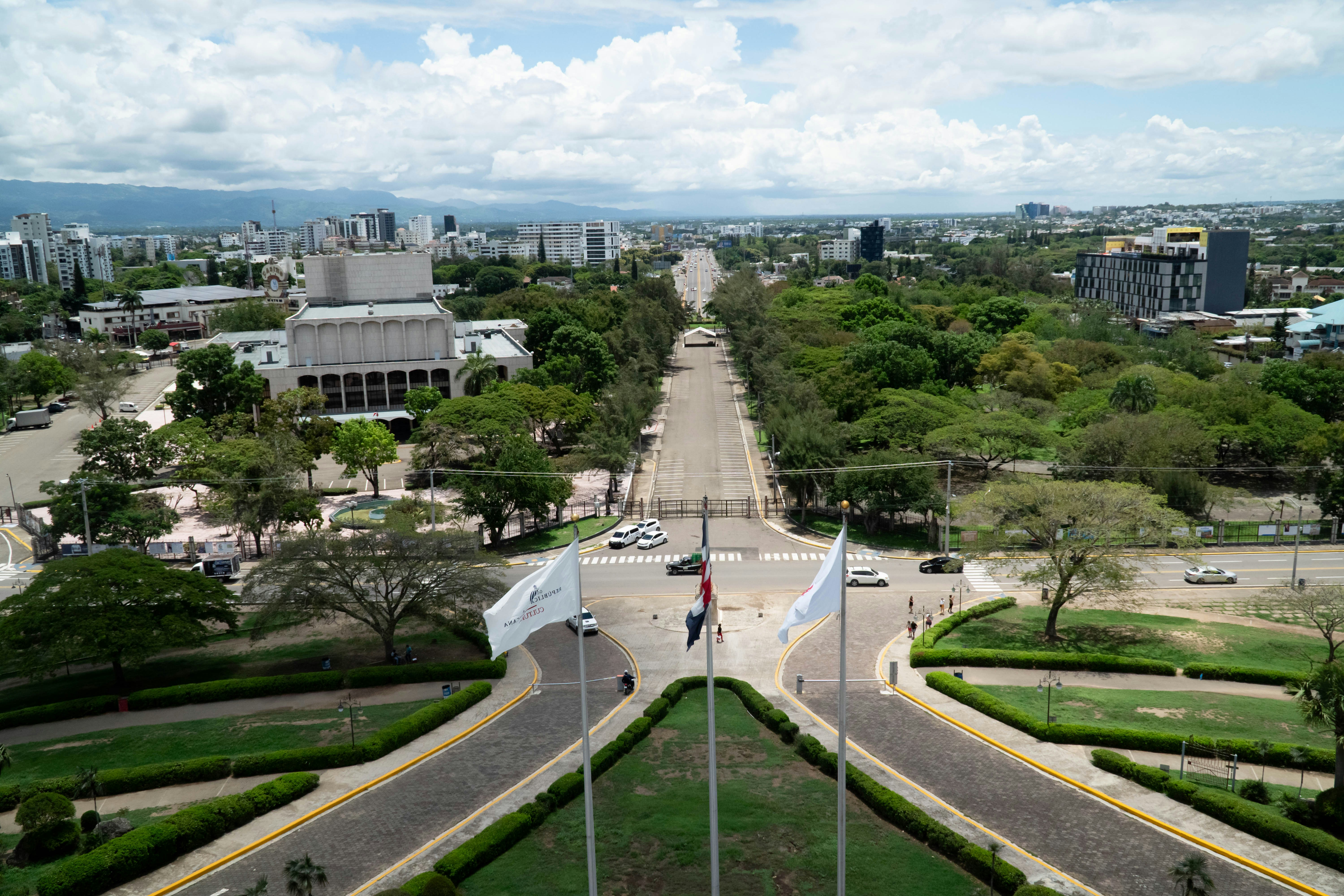 Wide avenue lined with trees in a modern city.