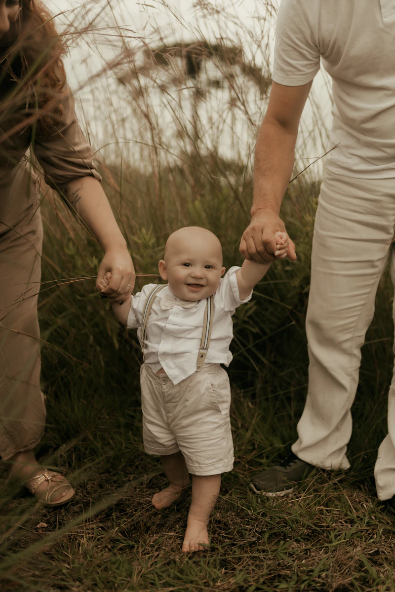Parents holding hands with their happy toddler walking outdoors
