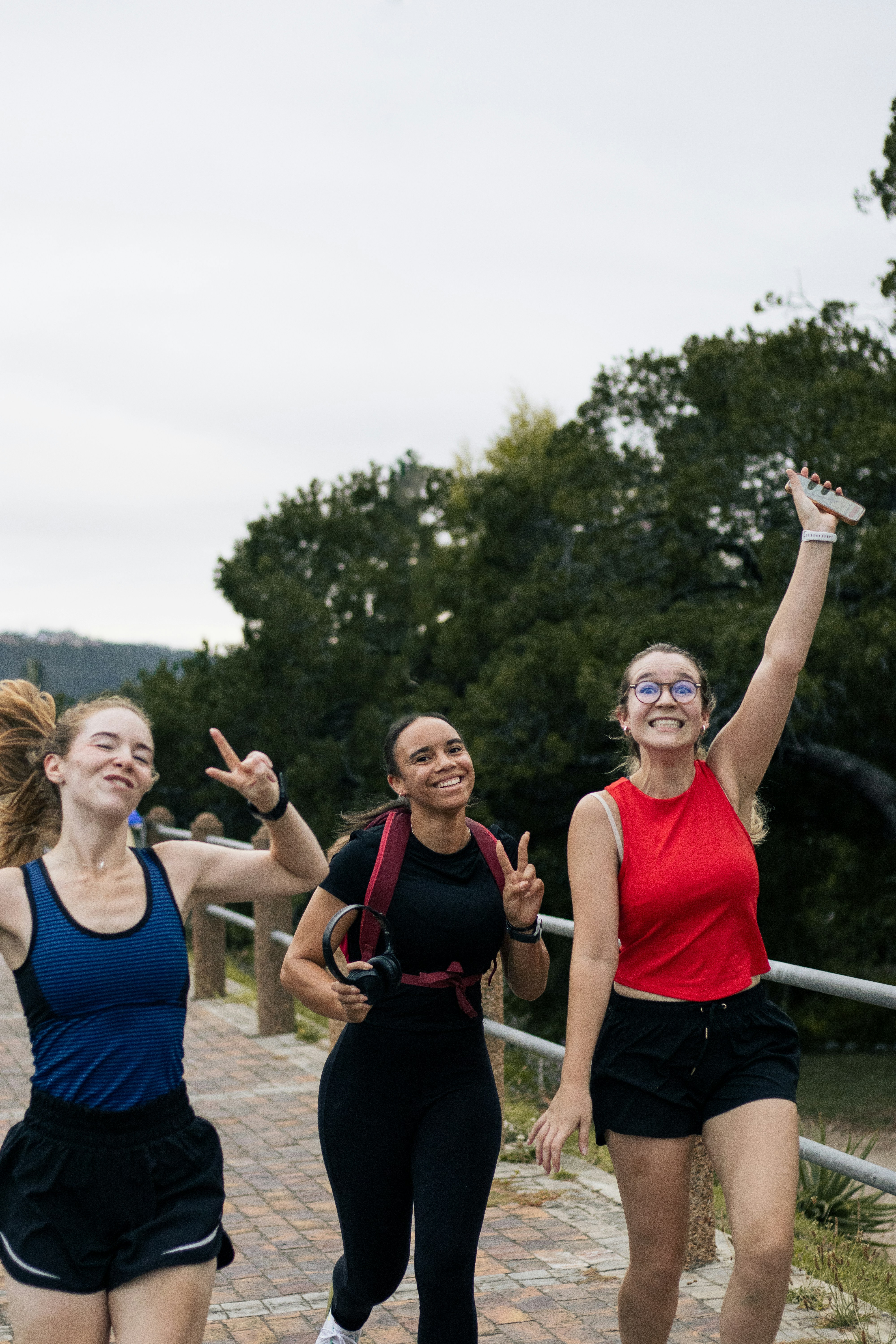 Three happy women running outdoors together