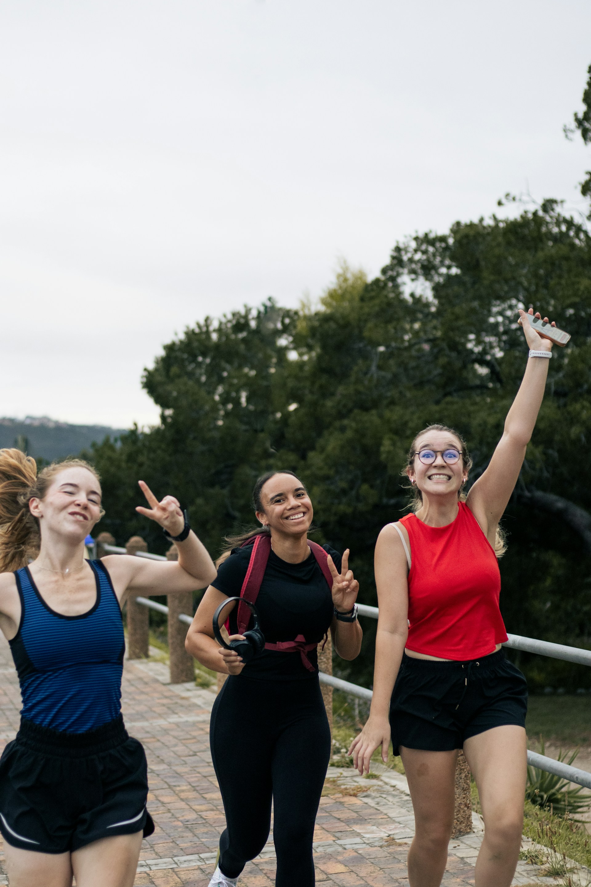 Three happy women running outdoors together