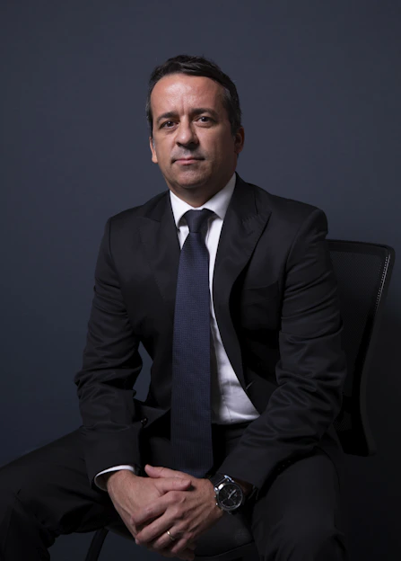 Man in a suit sitting with hands clasped