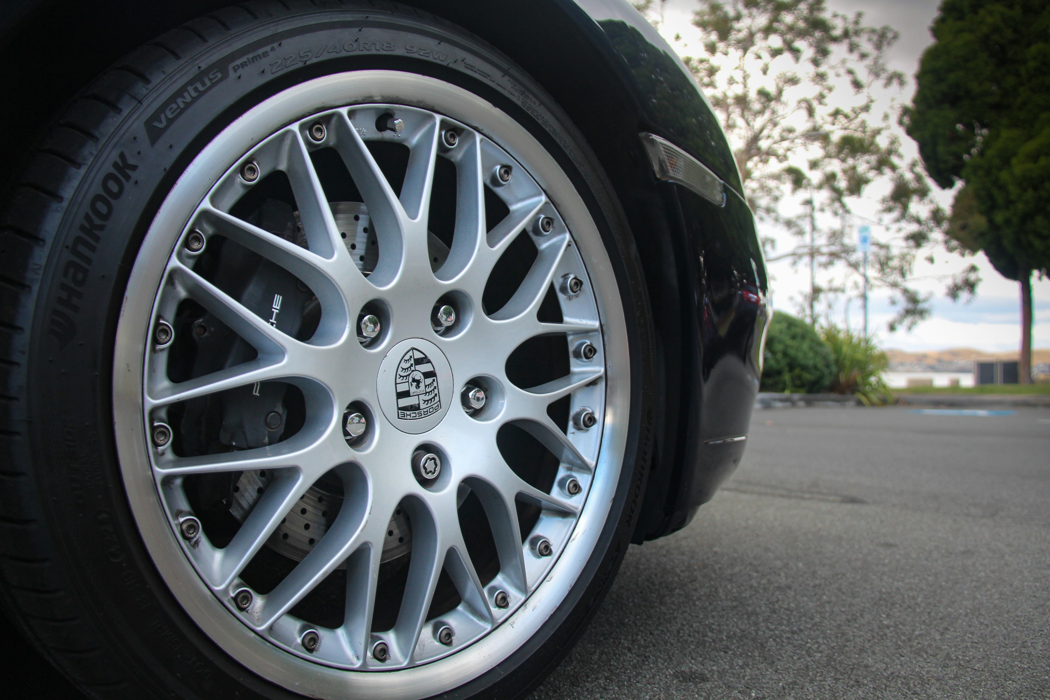 Close-up of a silver alloy car wheel with tire.