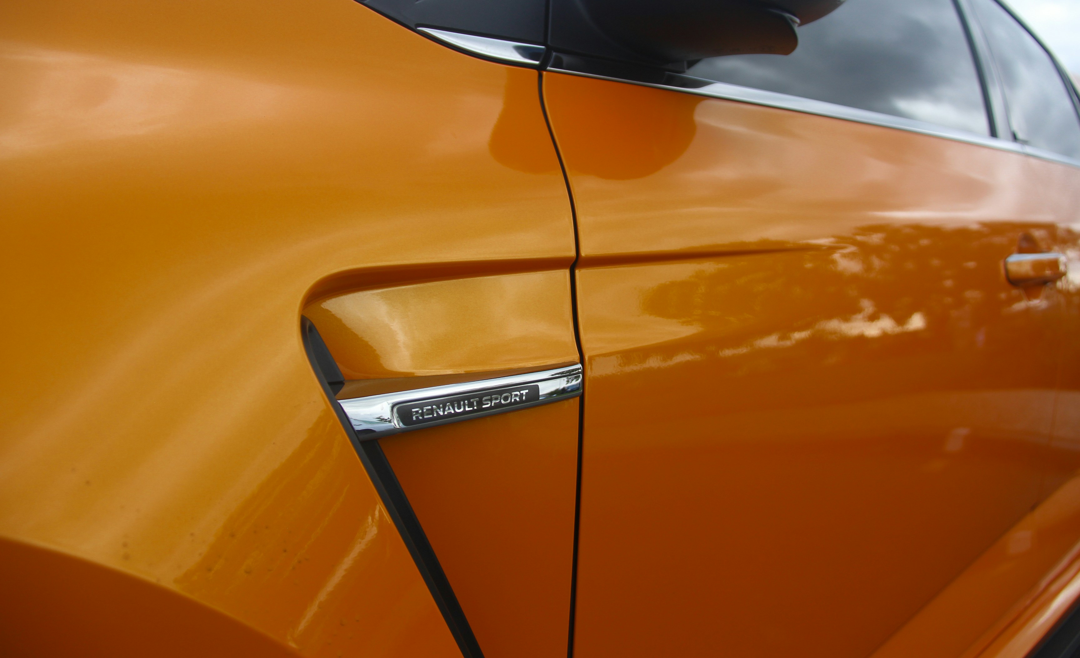 Close-up of an orange car's side vent detail