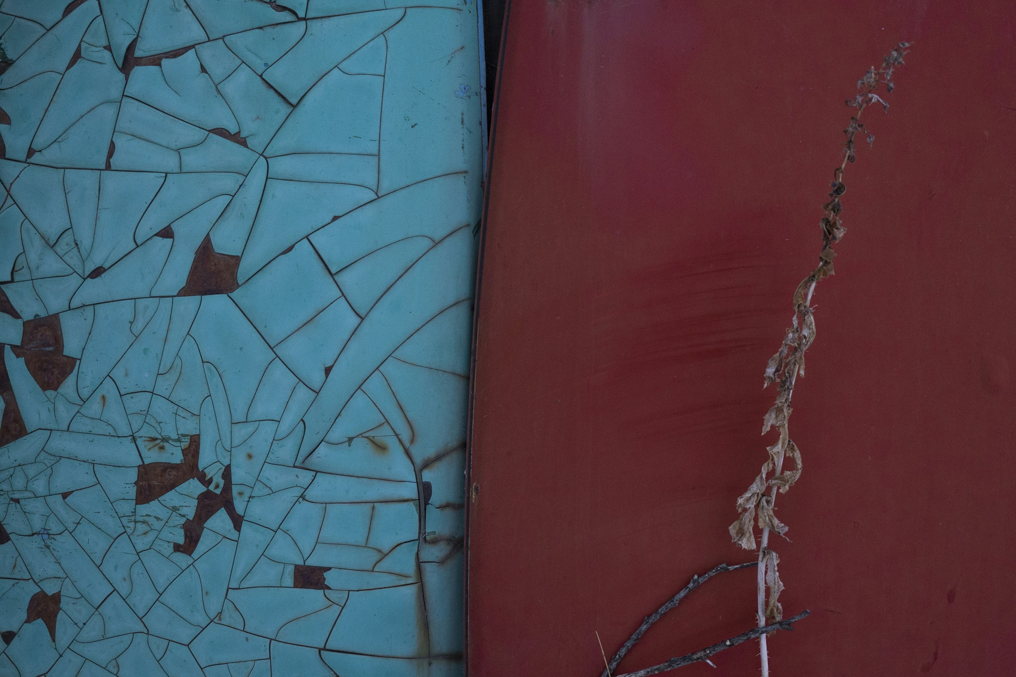 Cracked blue paint next to solid red surface