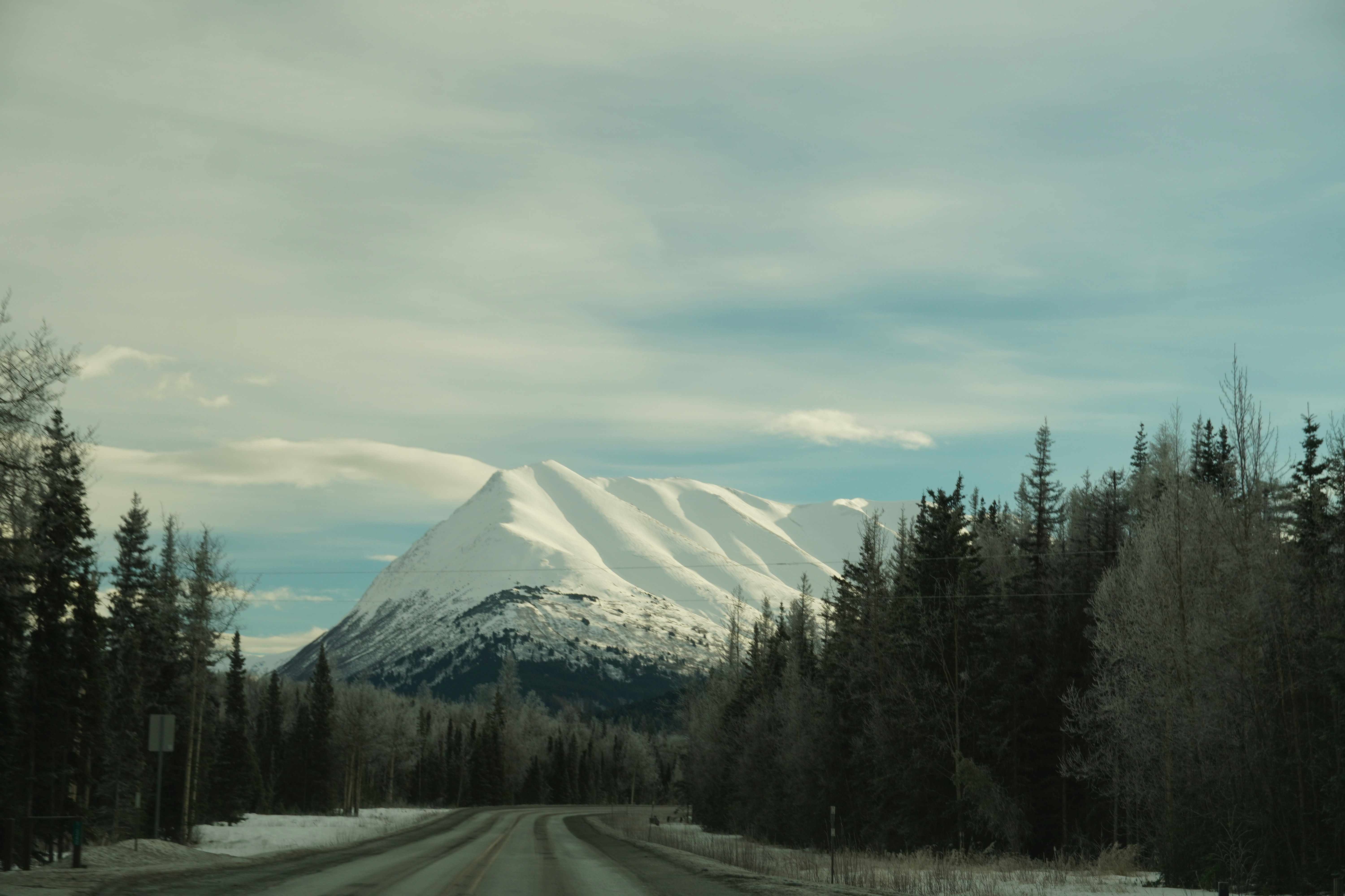 Snow covered mountain peak seen from a road
