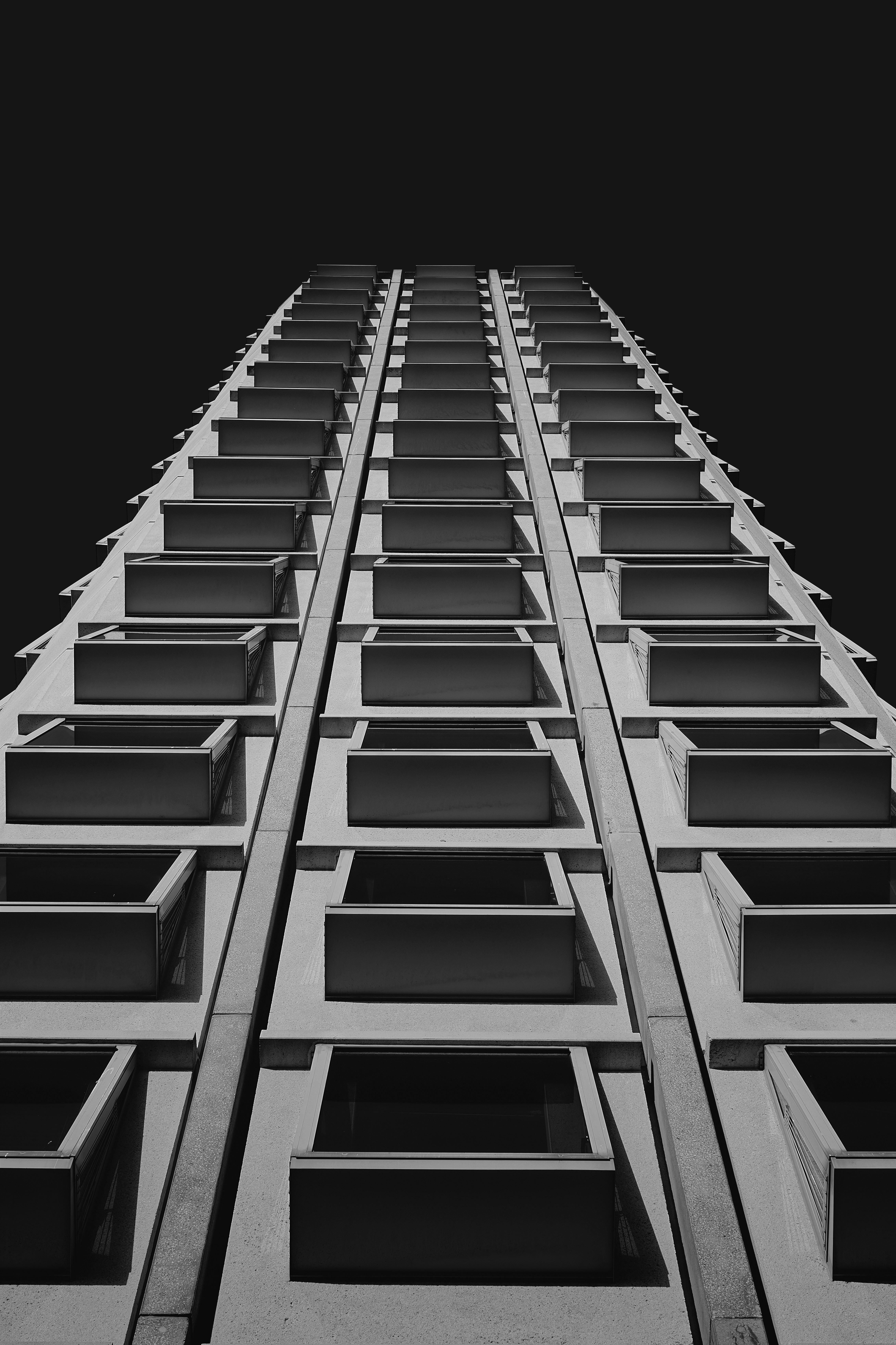 Modern apartment building with repeating balconies against dark sky