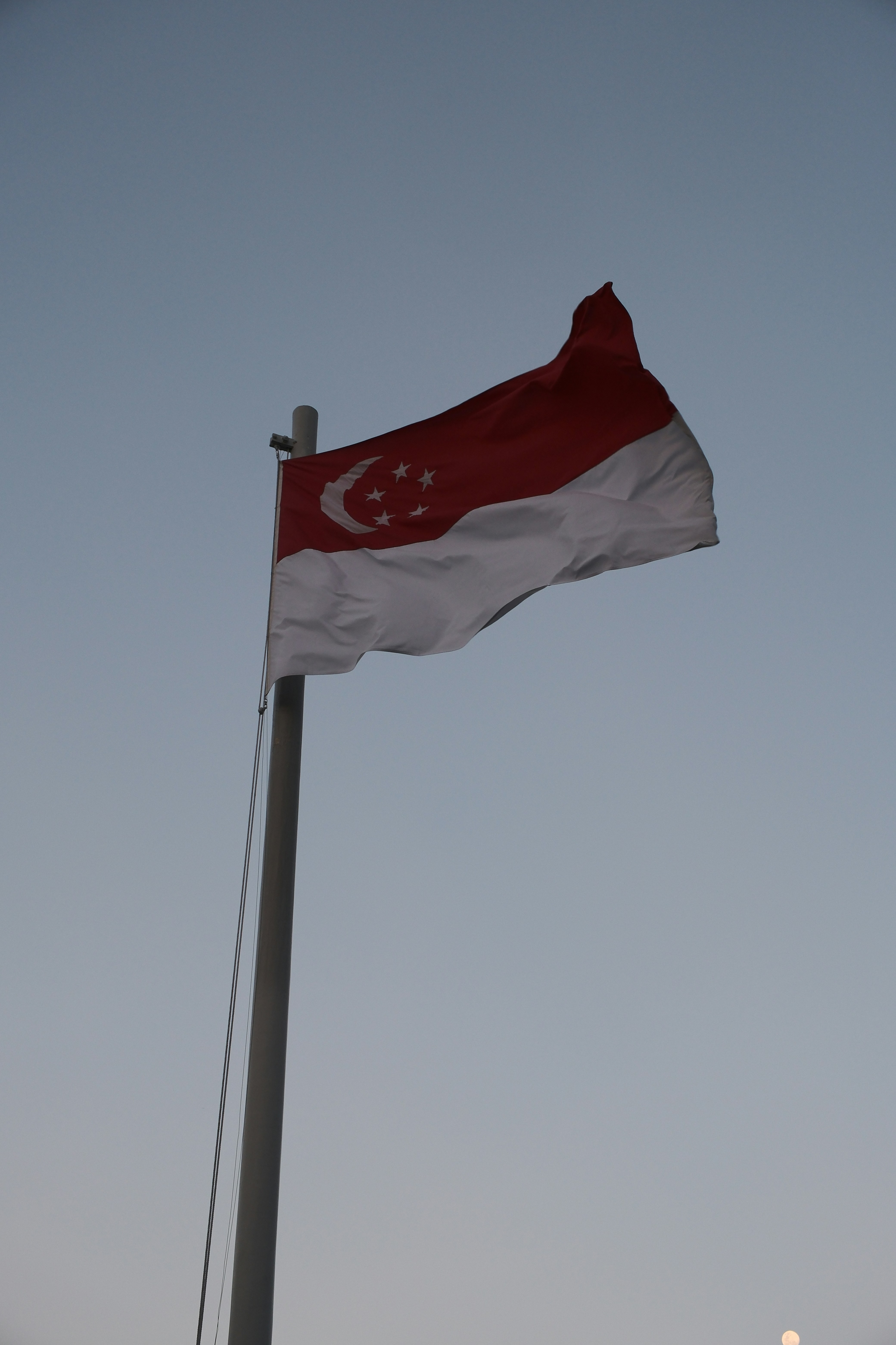 Bandiera di Singapore che sventola contro un cielo azzurro limpido