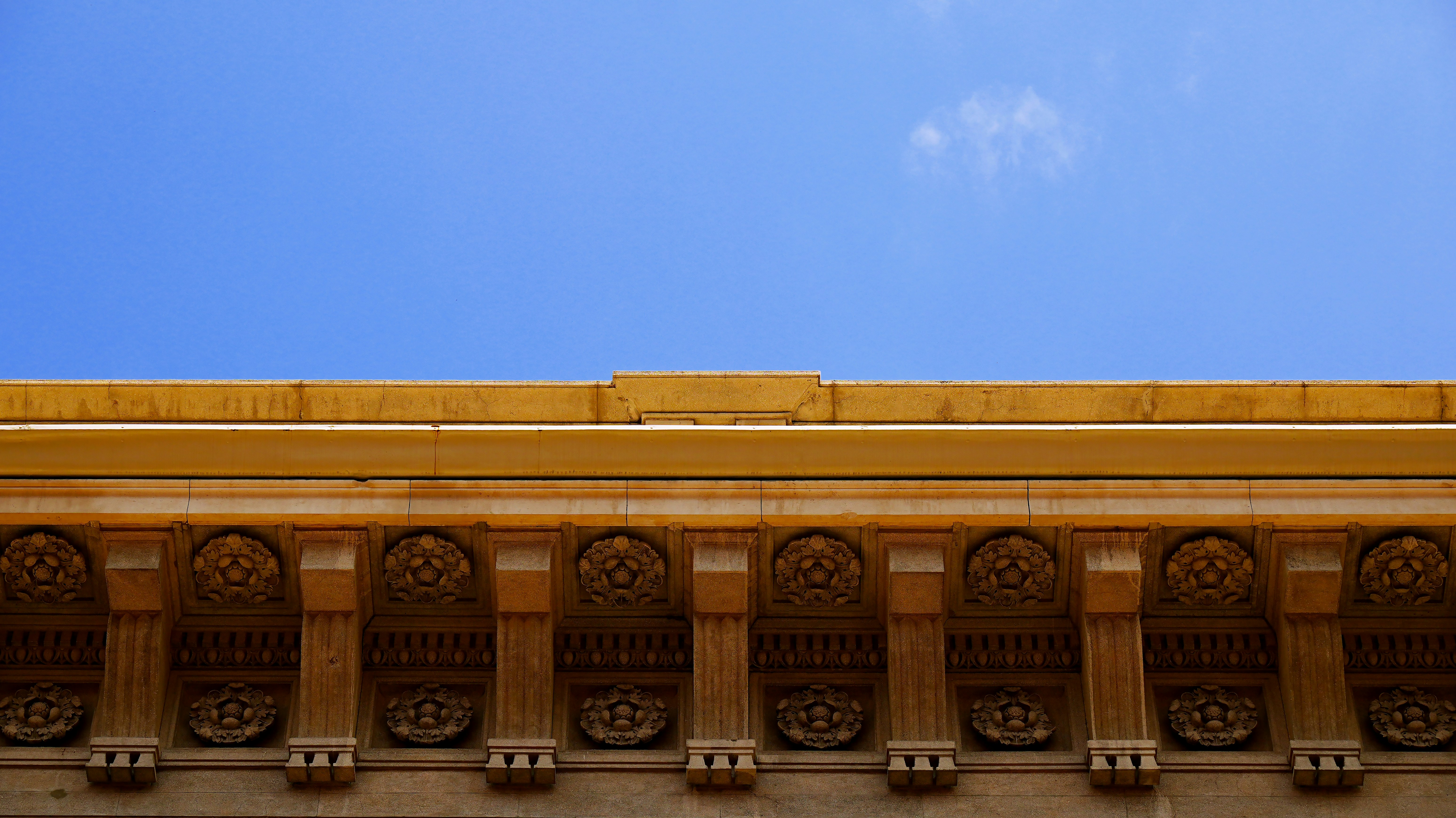 Verzierte architektonische Details vor einem strahlend blauen Himmel.