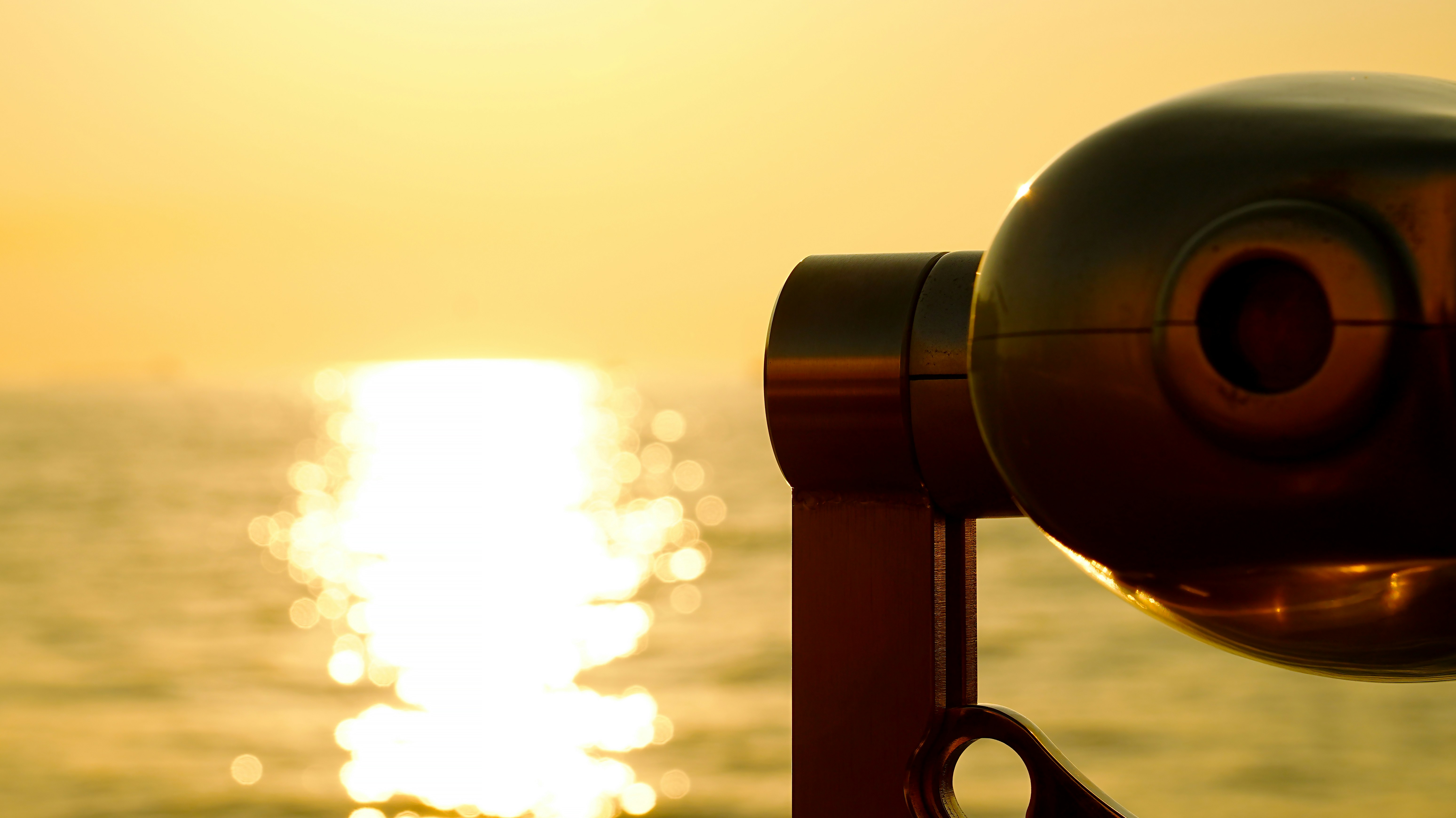 Fernglas mit Blick auf das Meer bei Sonnenuntergang.