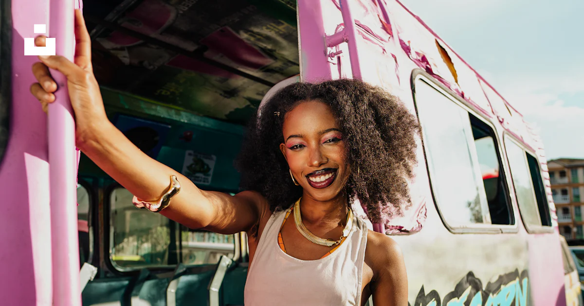 Pink Bus Lady A smiling woman stands by a pink bus. photo – Free Fashion Image on ...