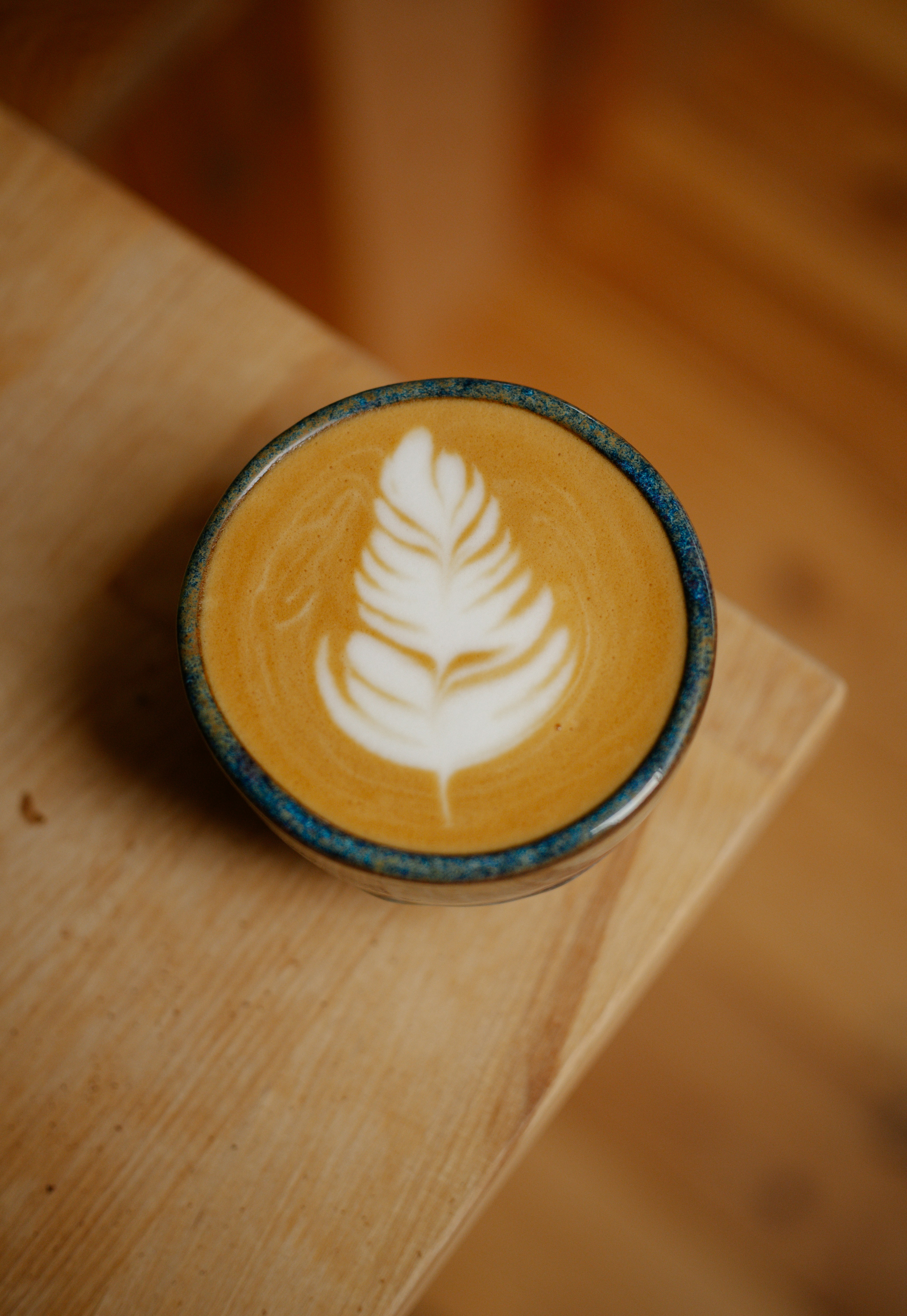 Latte art in a ceramic cup on a wooden surface