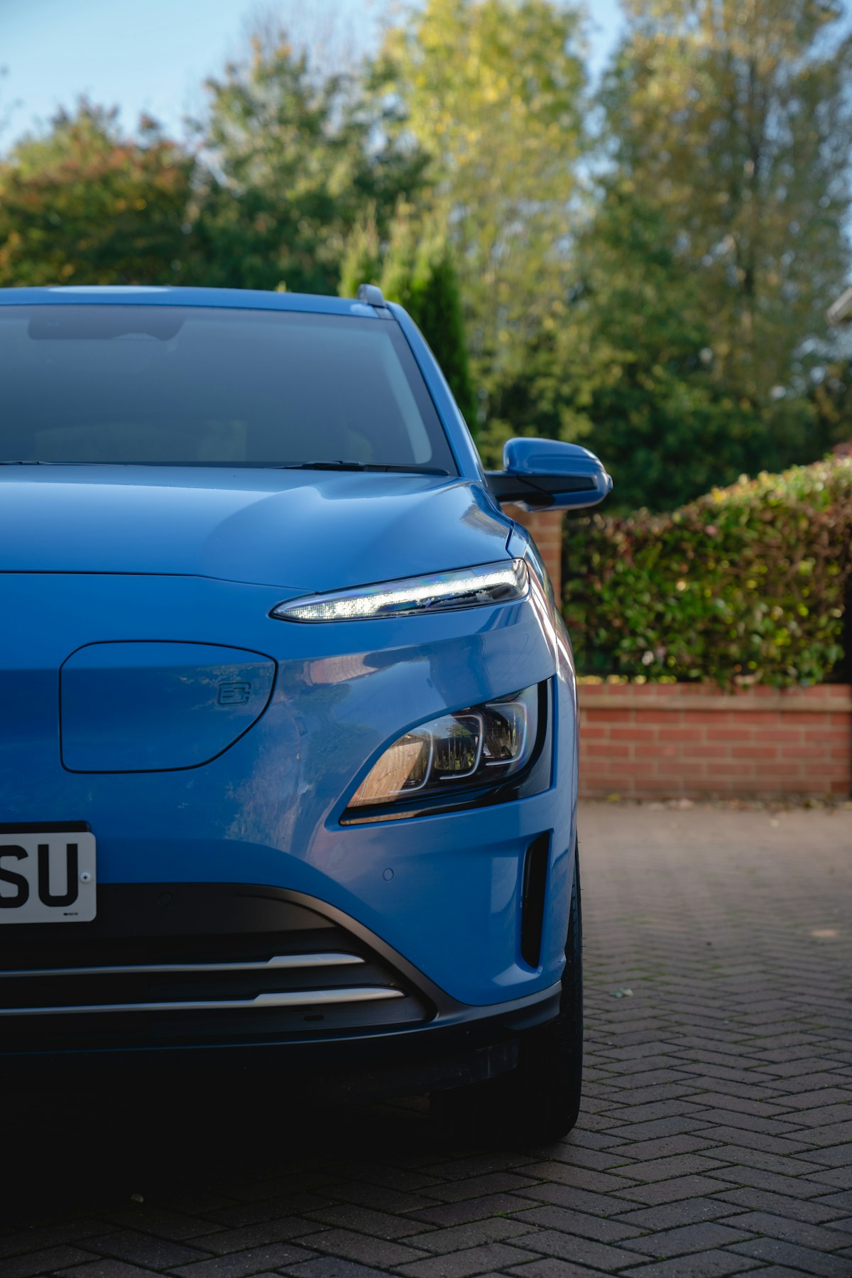 A blue electric SUV parked on a residential driveway, representing the growing electric vehicle market