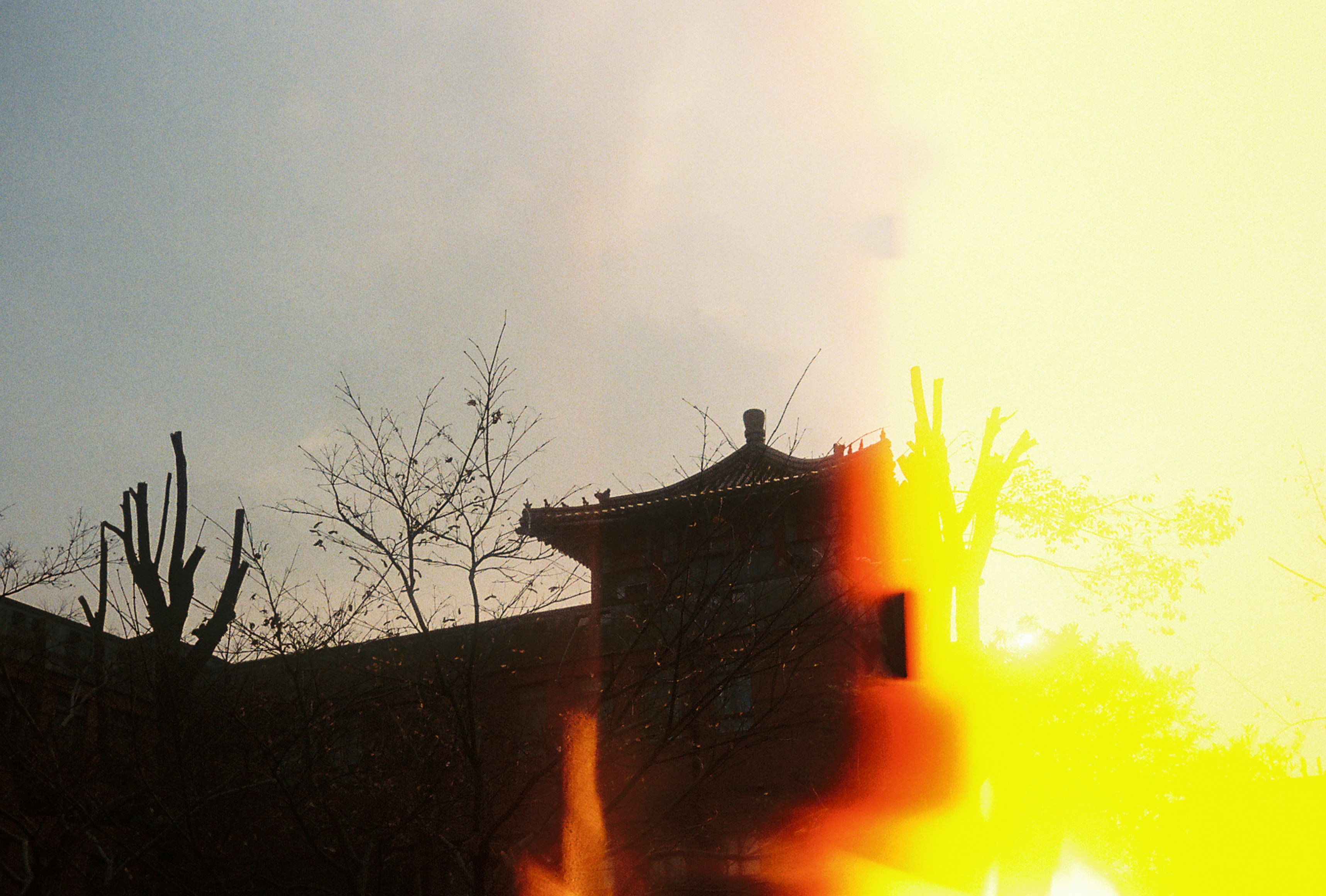 Traditional building silhouette against bright sun flare.