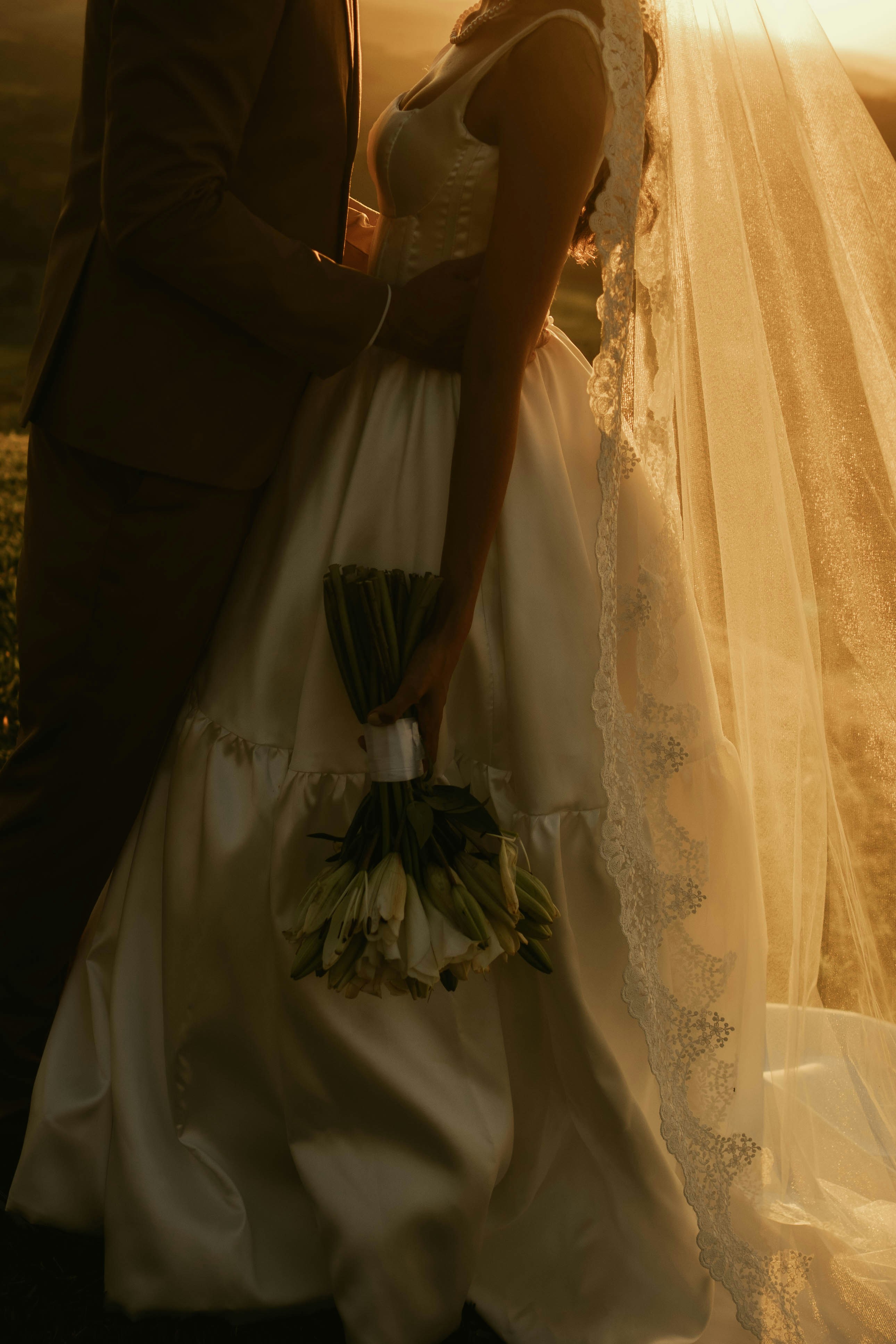 Braut und Bräutigam umarmen sich bei Sonnenuntergang