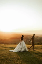 Bride and groom holding hands at sunset