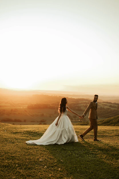 Bride and groom holding hands at sunset