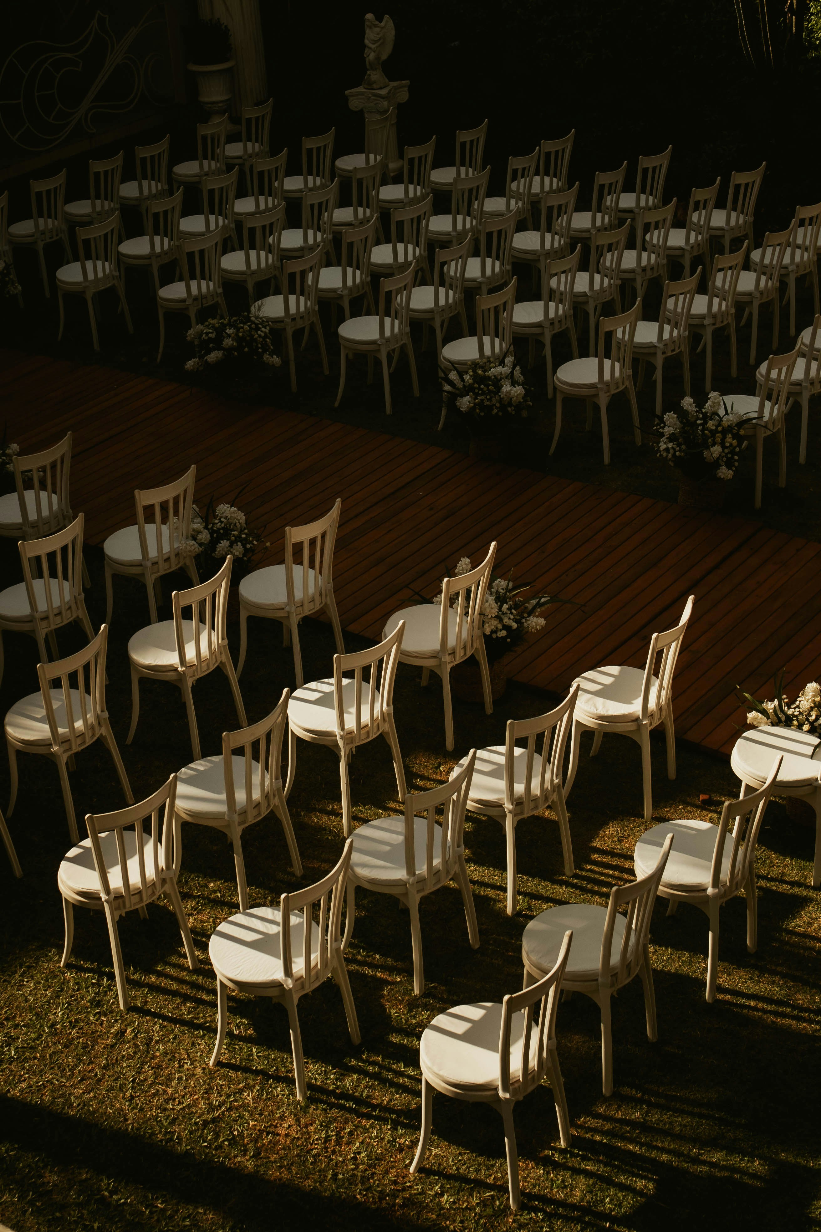 Rows of white chairs set up for an outdoor event.