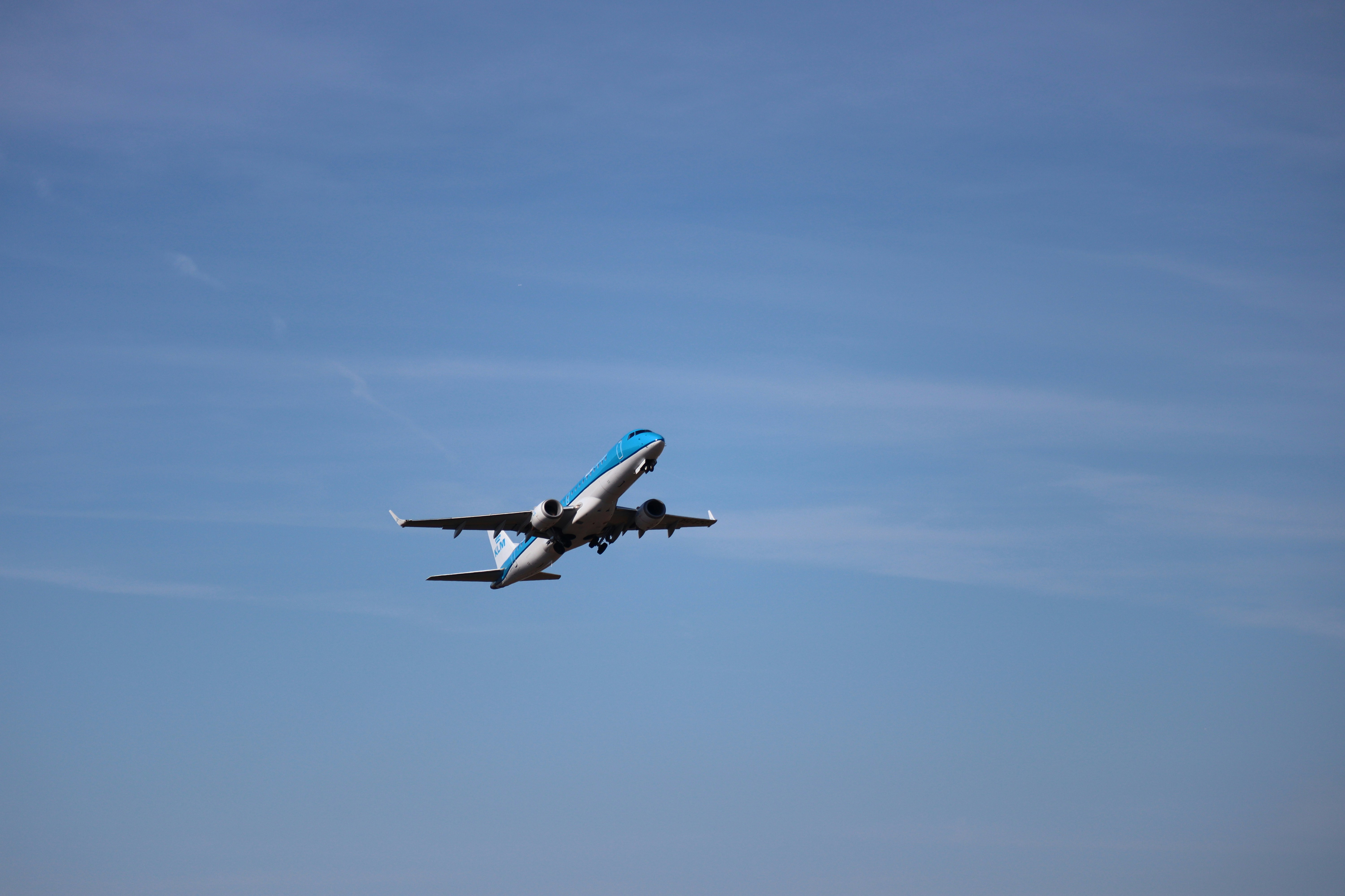 An airplane ascending into a clear blue sky