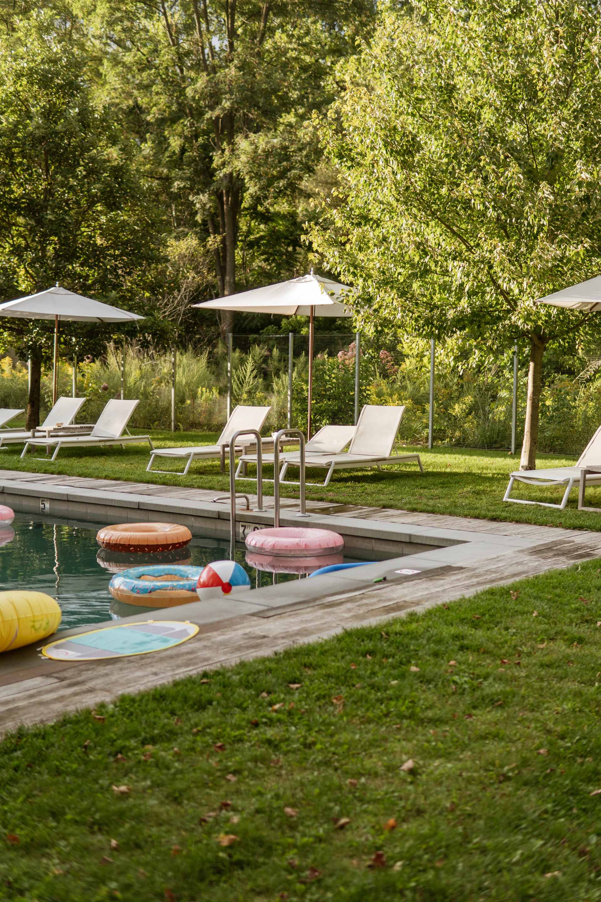 Swimming pool with inflatable rings and lounge chairs