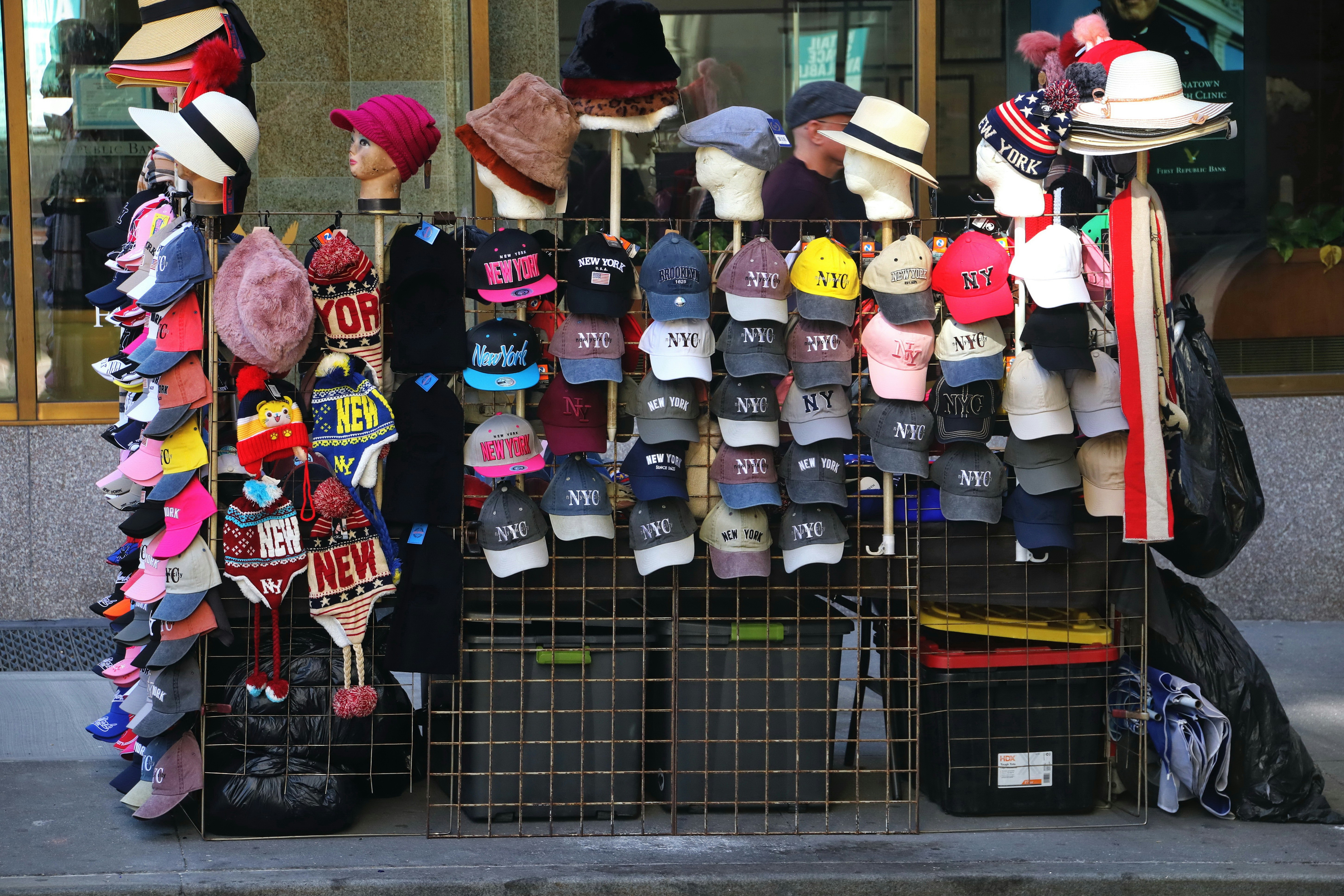 Street vendor selling hats and caps on display.