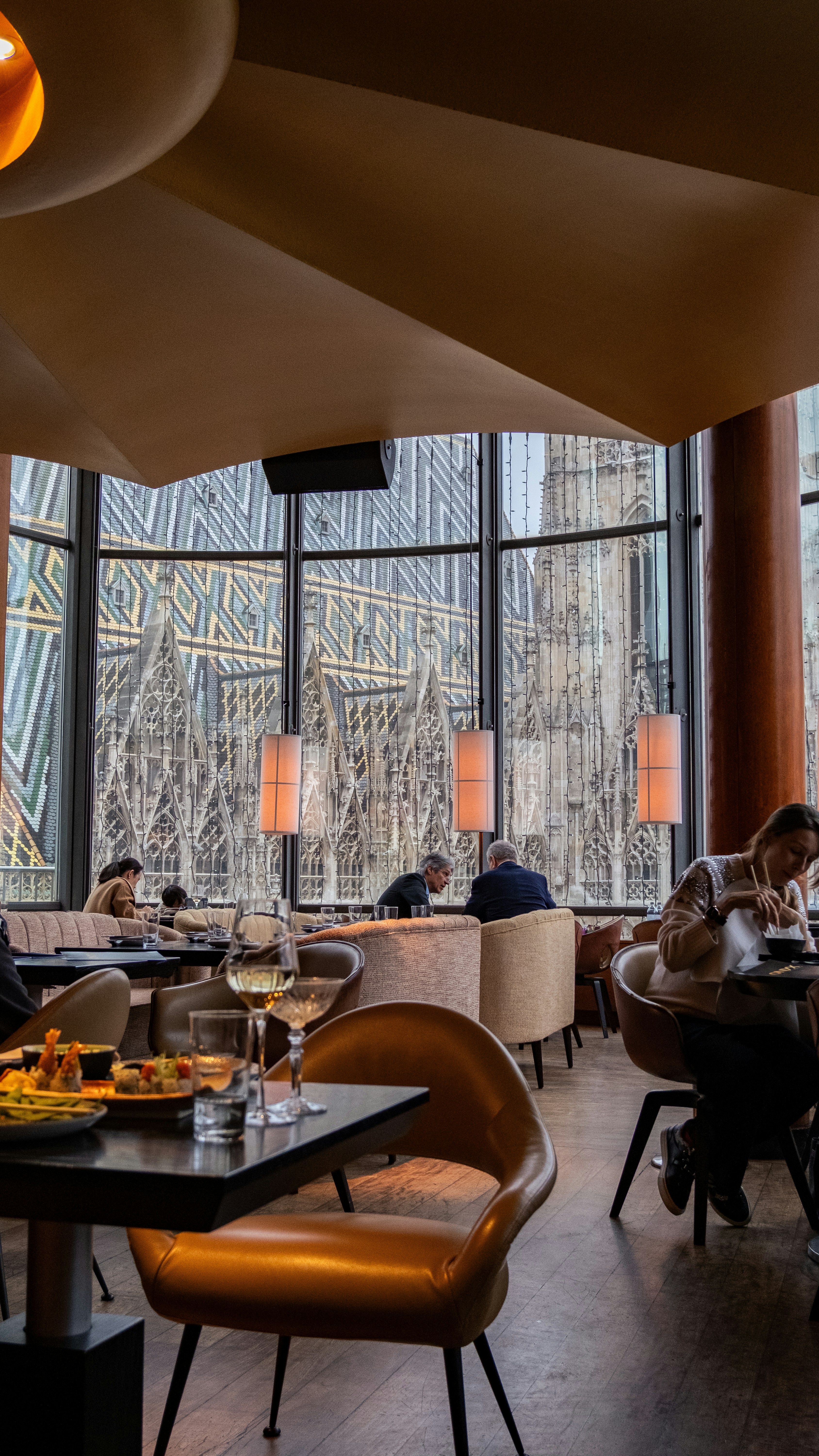 People dining in a restaurant with a cathedral view.