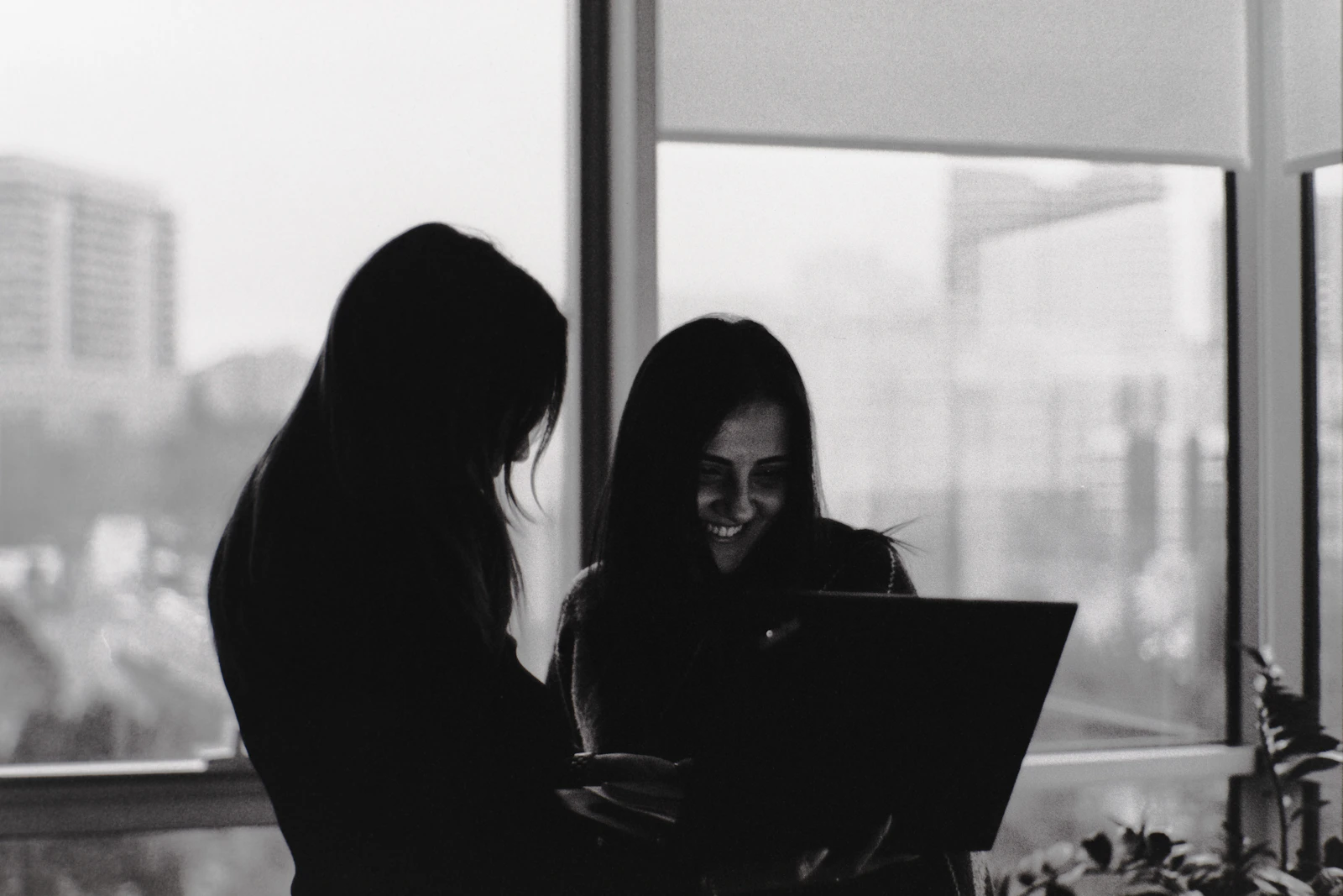 Two women colleagues reviewing work together on a laptop