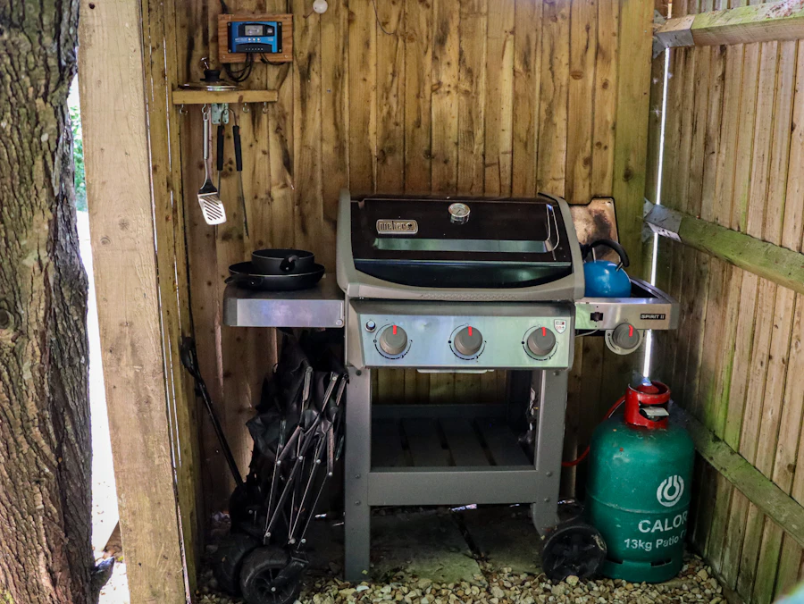 A propane grill and cylinder set up in a backyard shelter