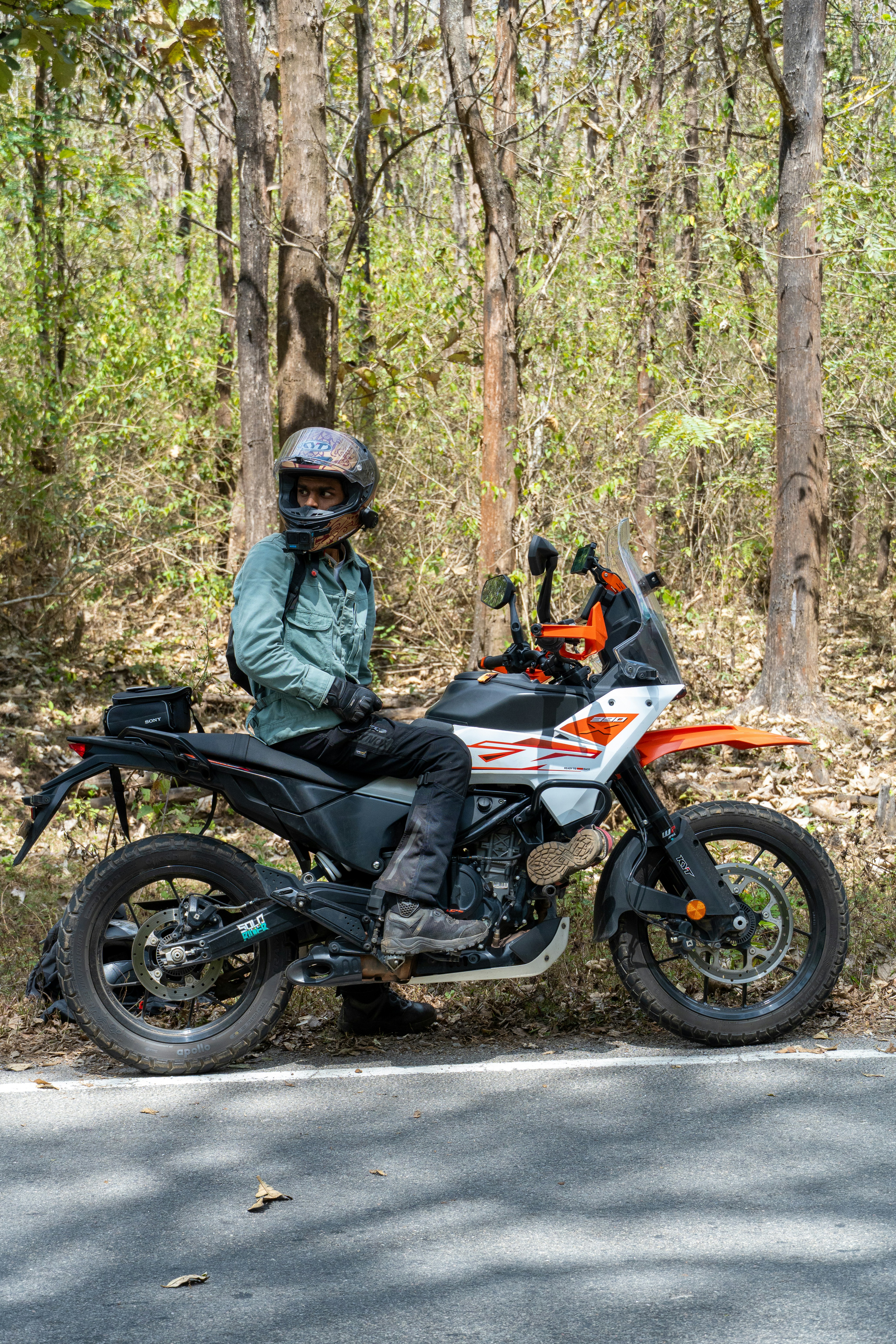Man in helmet sitting on adventure motorcycle in forest