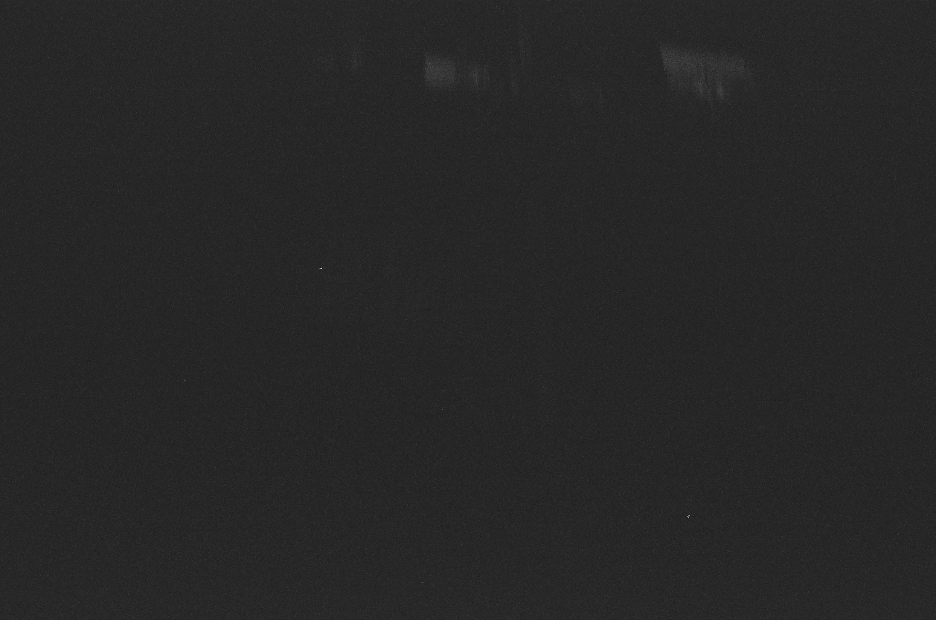 A dark, grainy background with faint lights