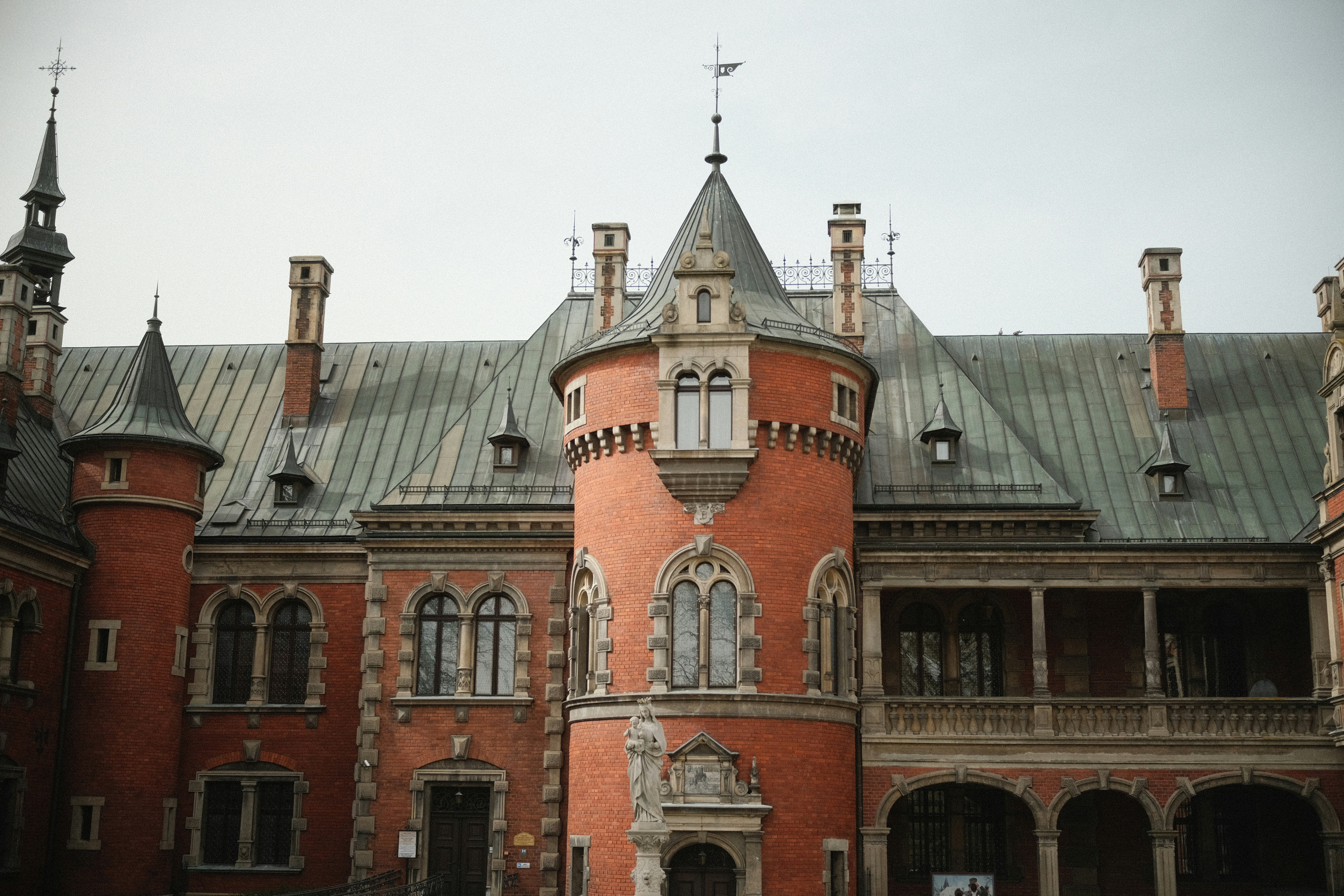 A historic red brick castle with ornate towers and windows.