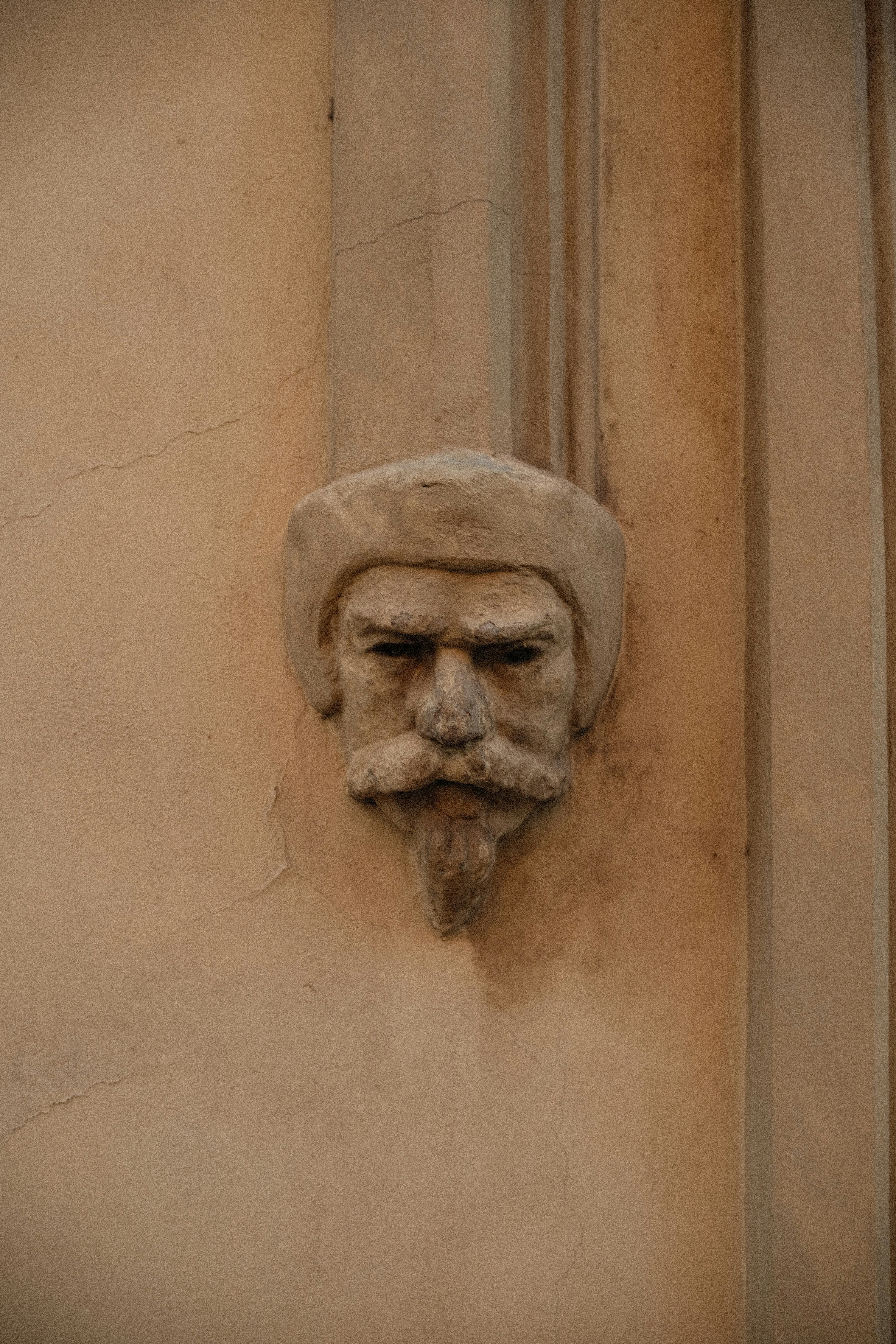 Stone gargoyle face on a textured wall