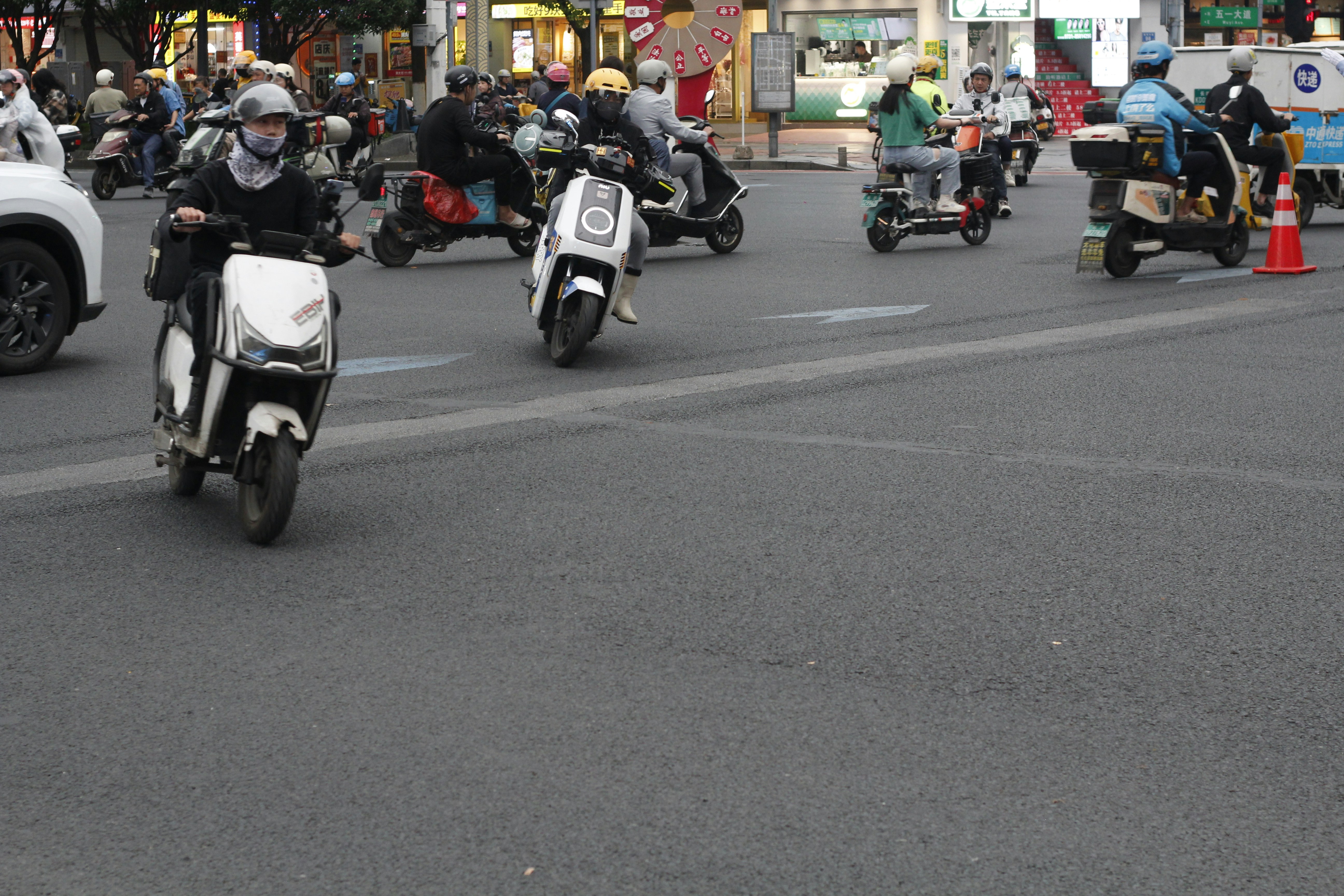 Motorcycles and scooters in traffic on a city street.
