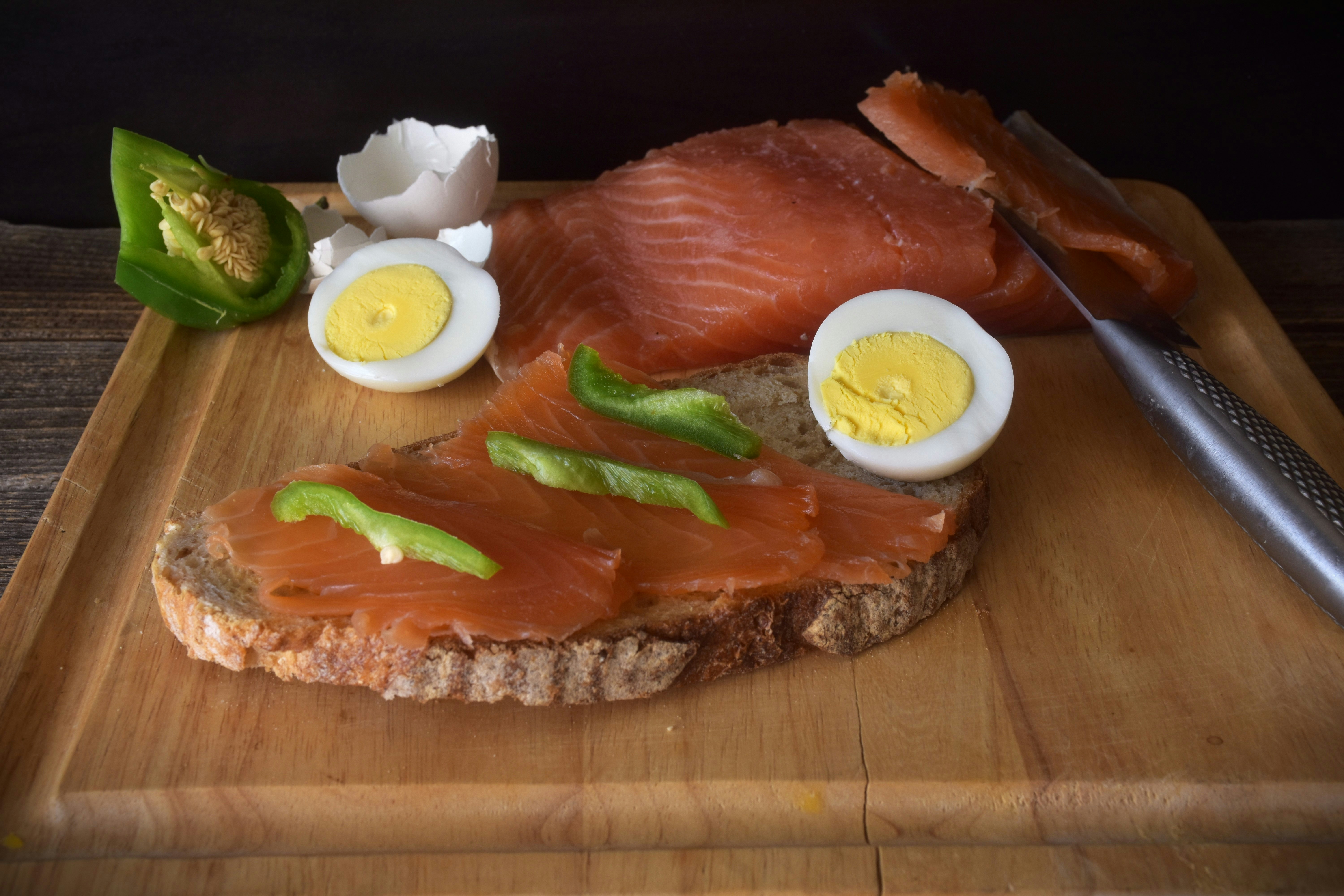 Smoked salmon on rye bread with hard-boiled eggs and peppers.