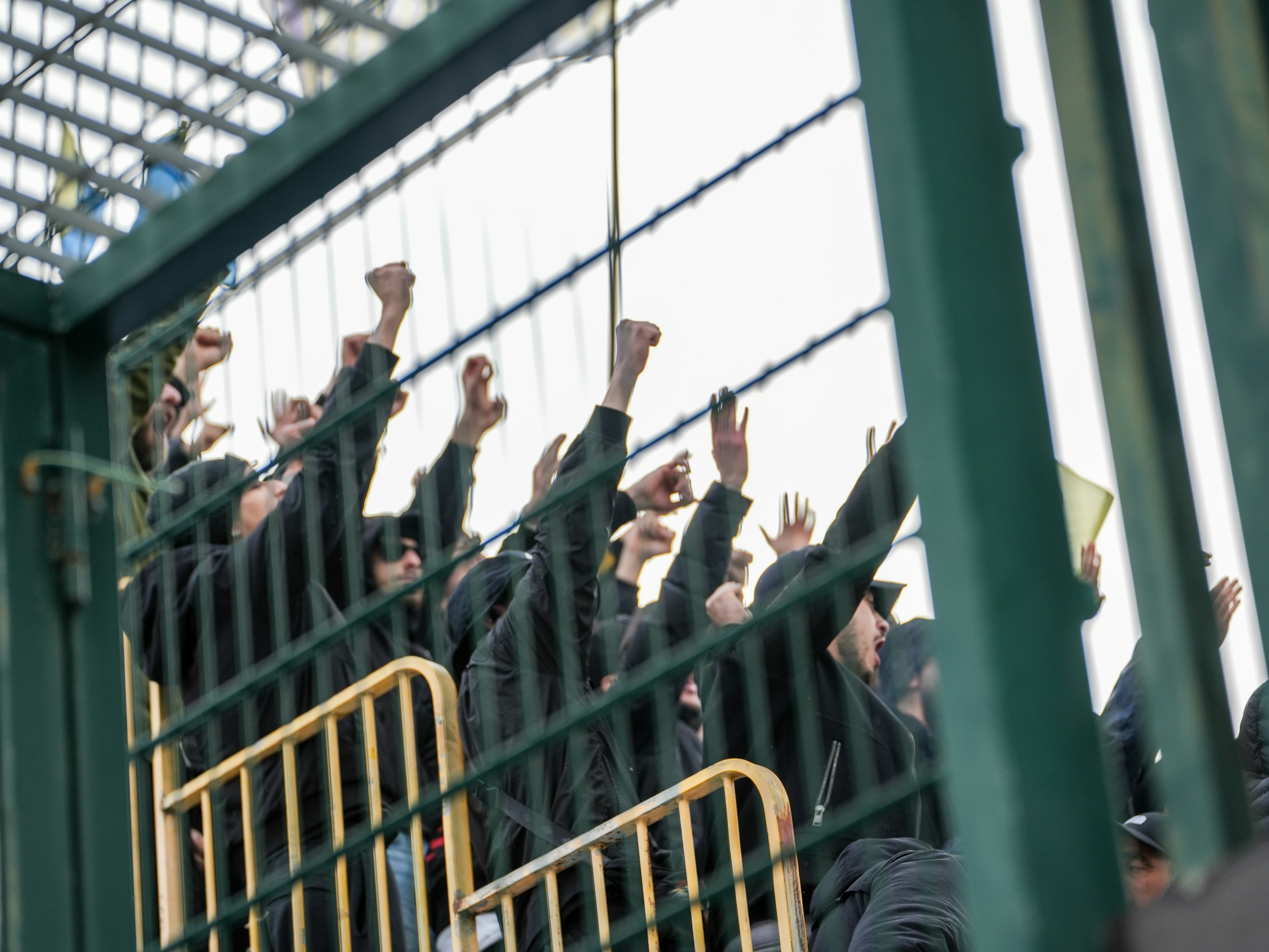 Un groupe de personnes vêtues de noir levant les poings.