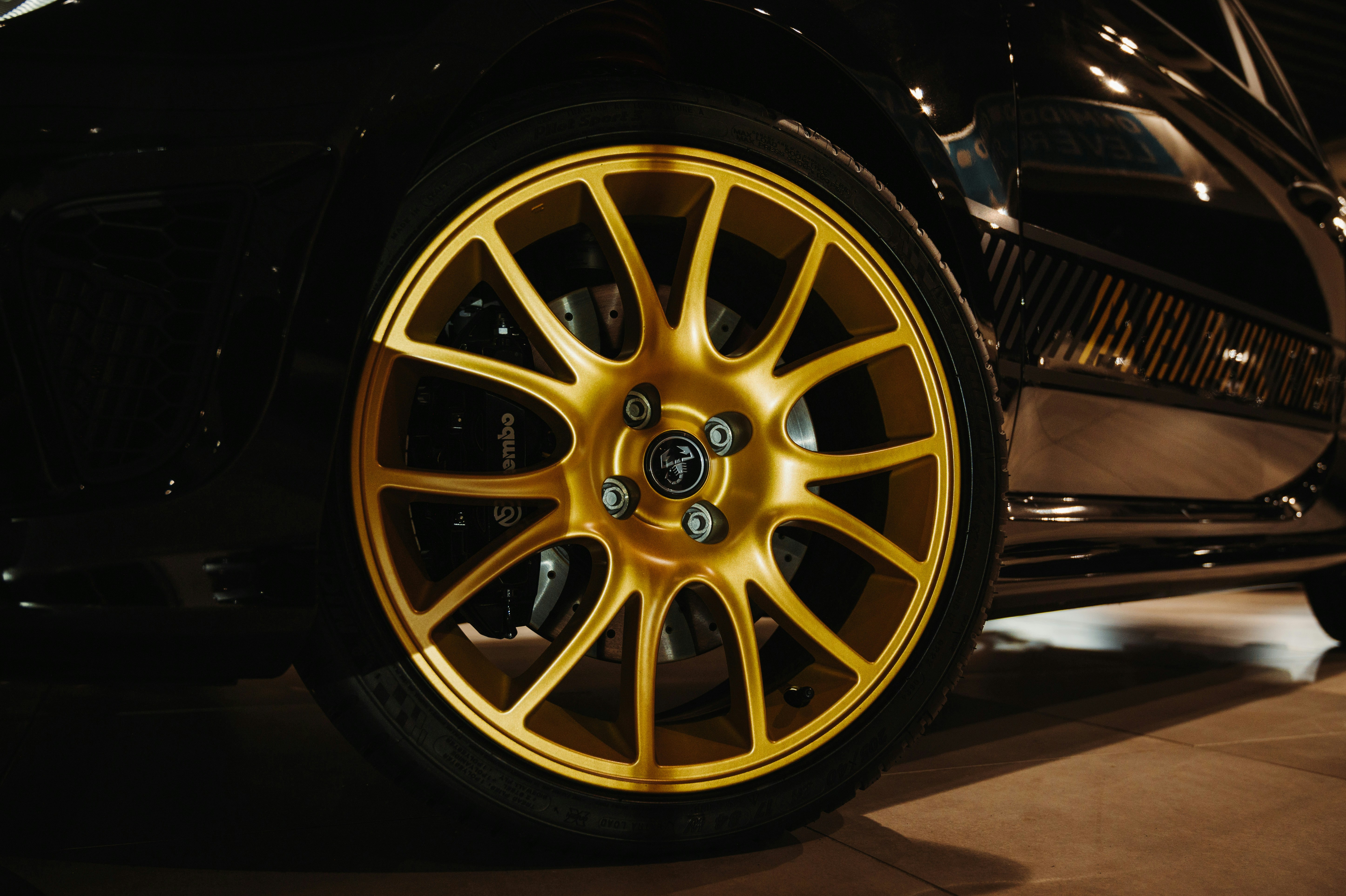 Close-up of a shiny gold car wheel on black car