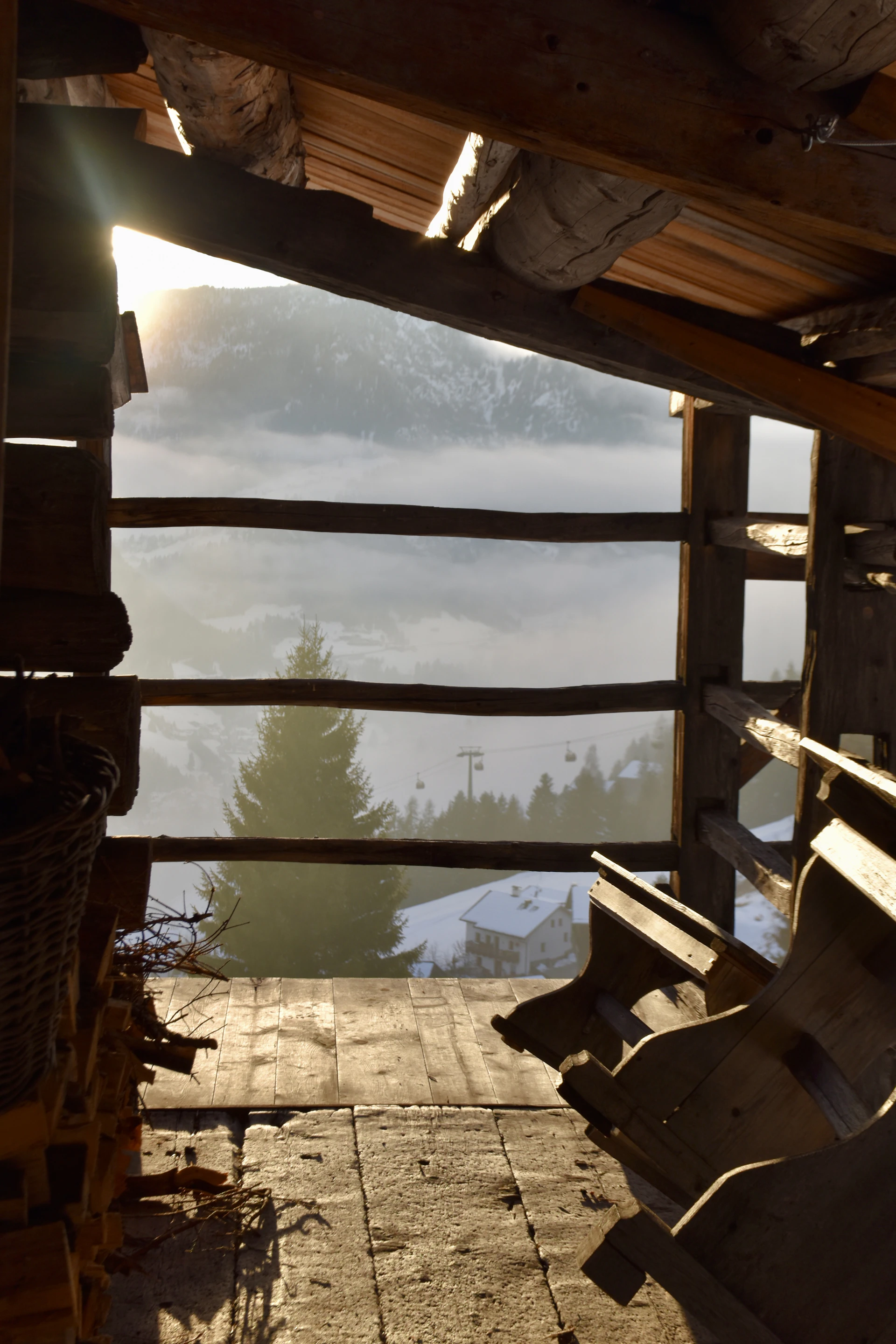 View through rustic wooden structure of snowy mountains
