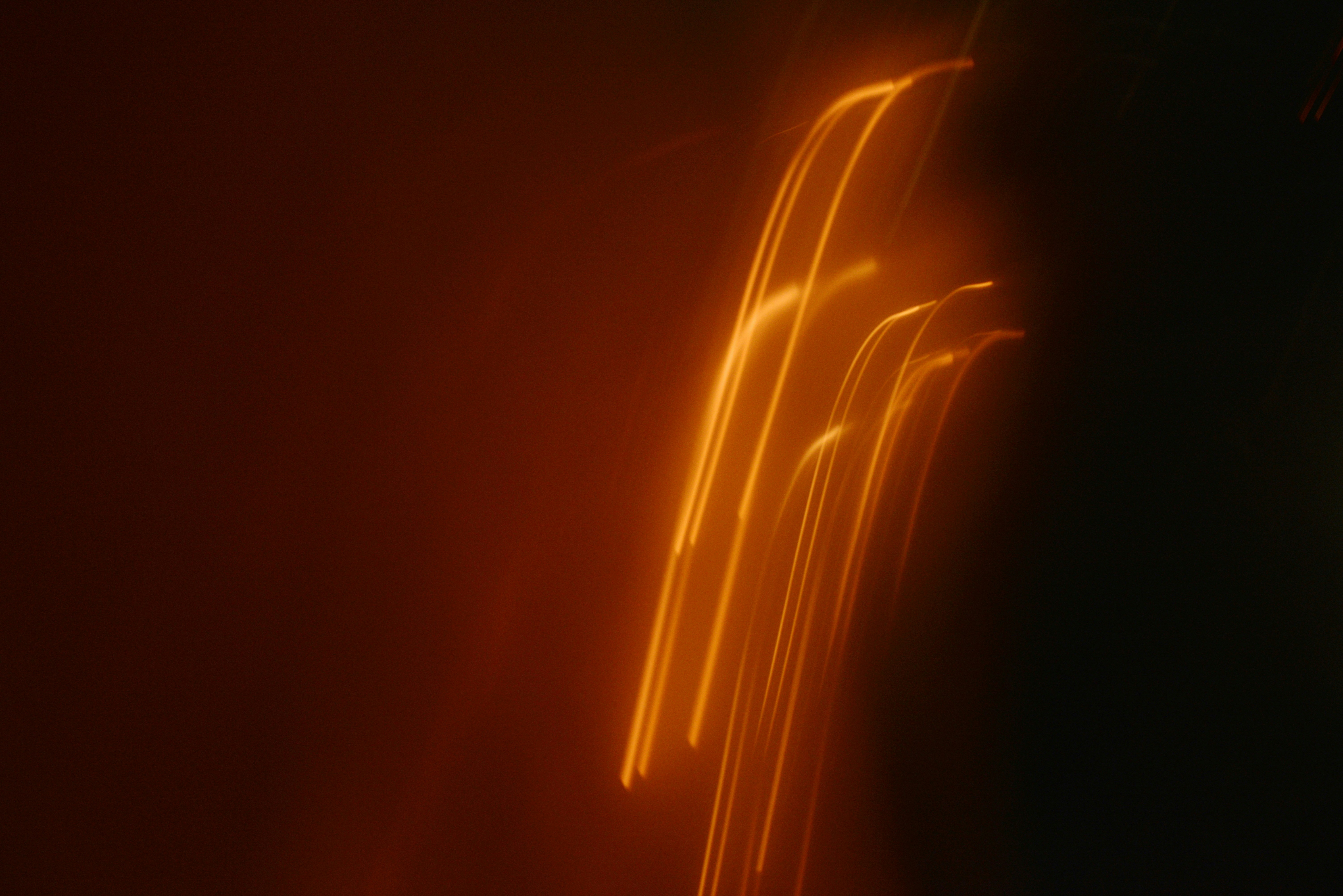 Abstract streaks of orange light against dark background