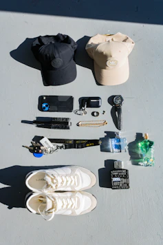 Collection of men's accessories including hats, phone, and cologne