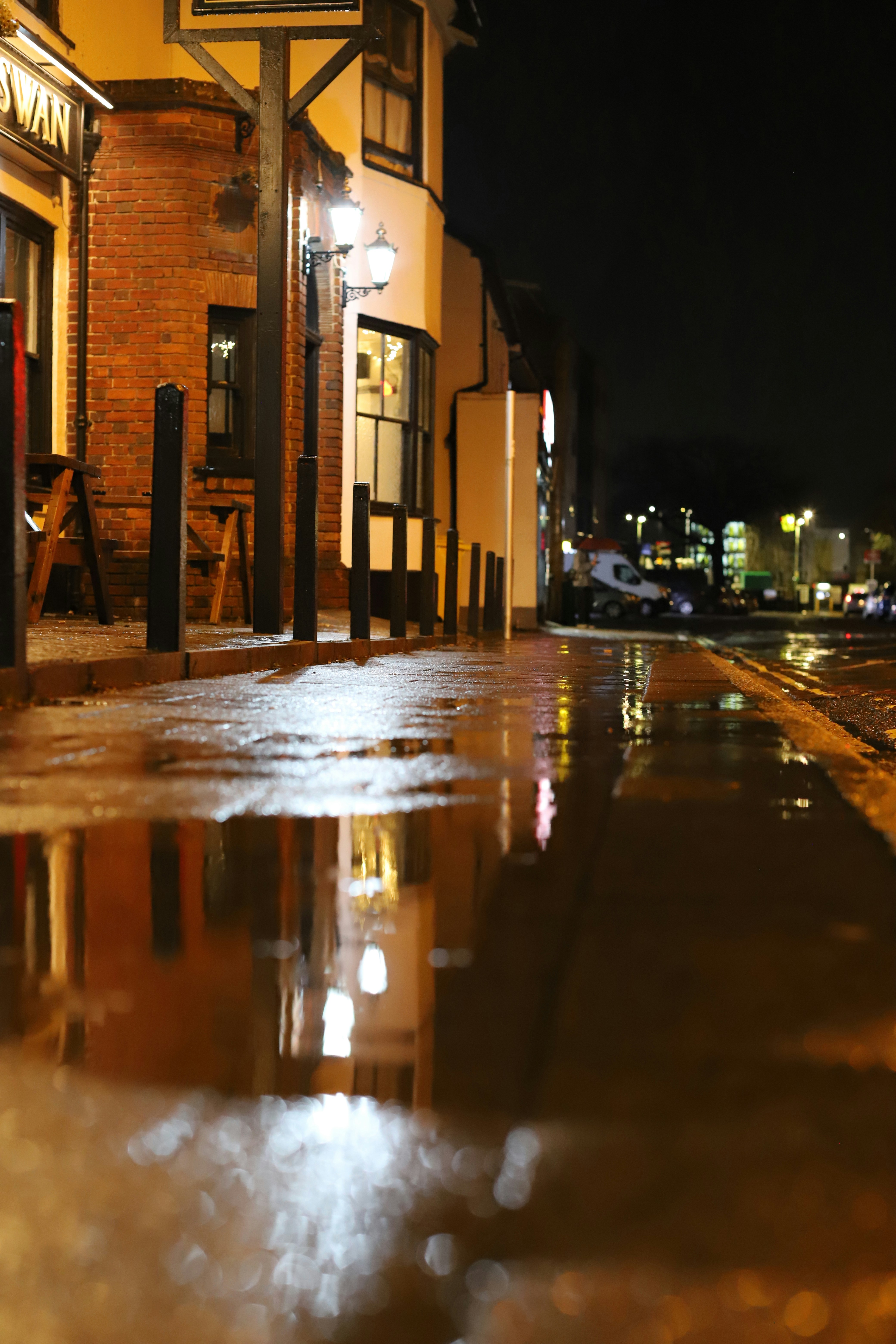 Wet street reflecting lights at night