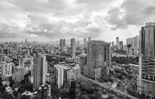 Monochrome cityscape with tall buildings under cloudy sky