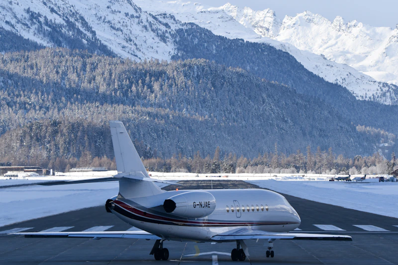 Private jet on a snowy runway with mountains behind