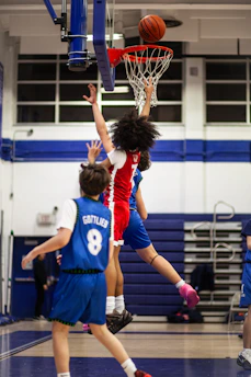 Basketball player dunks the ball during a game.