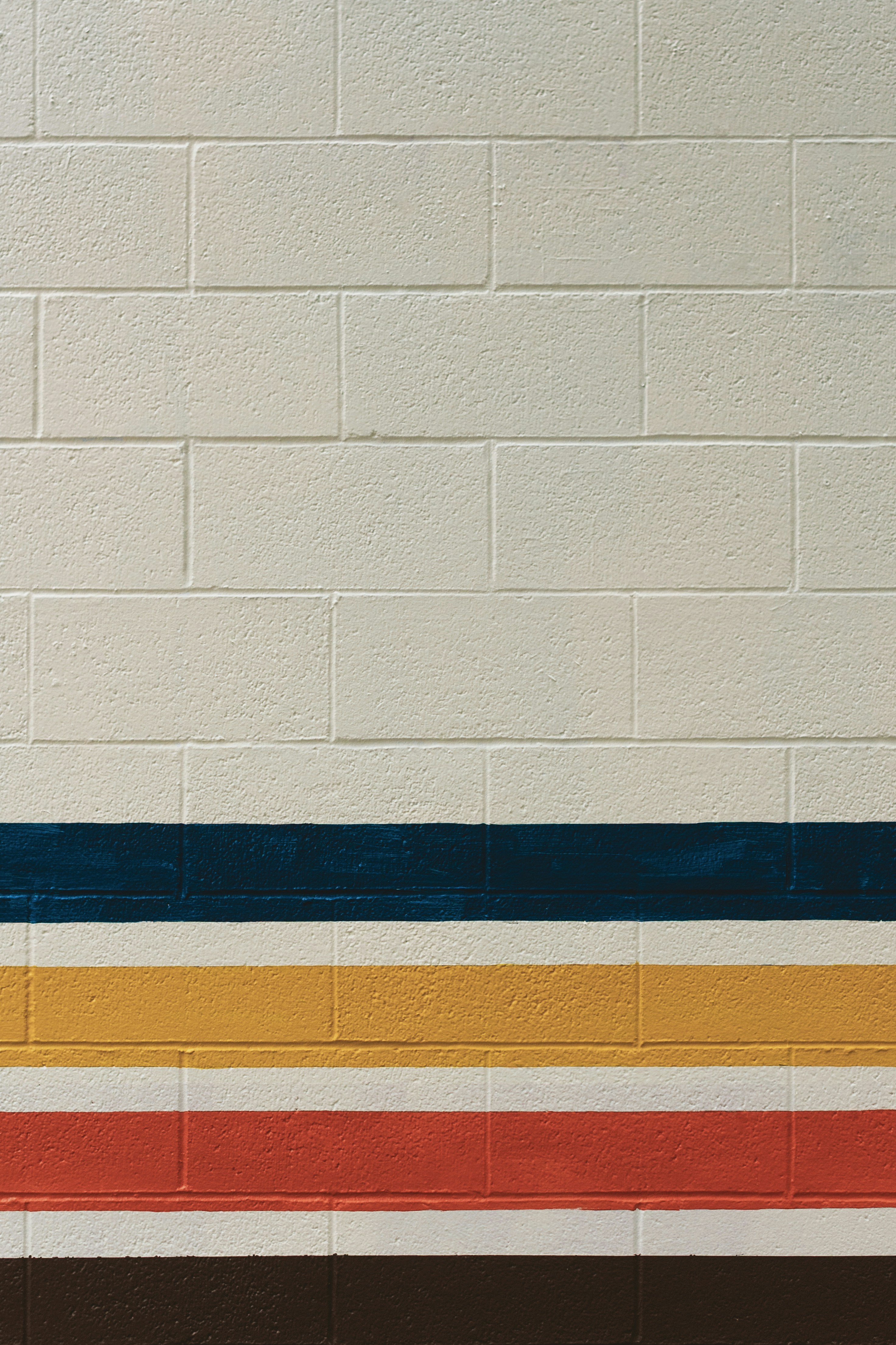 White brick wall with colorful horizontal stripes.