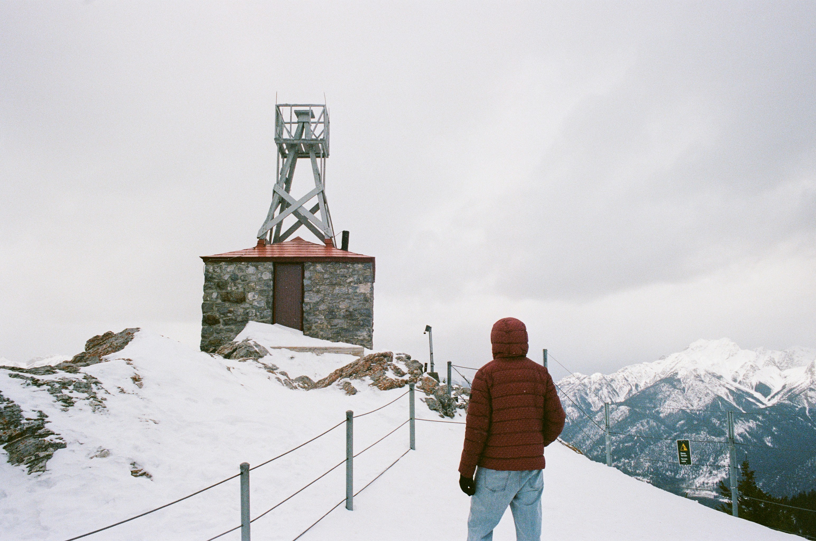 Person walks towards a stone building with a tower.