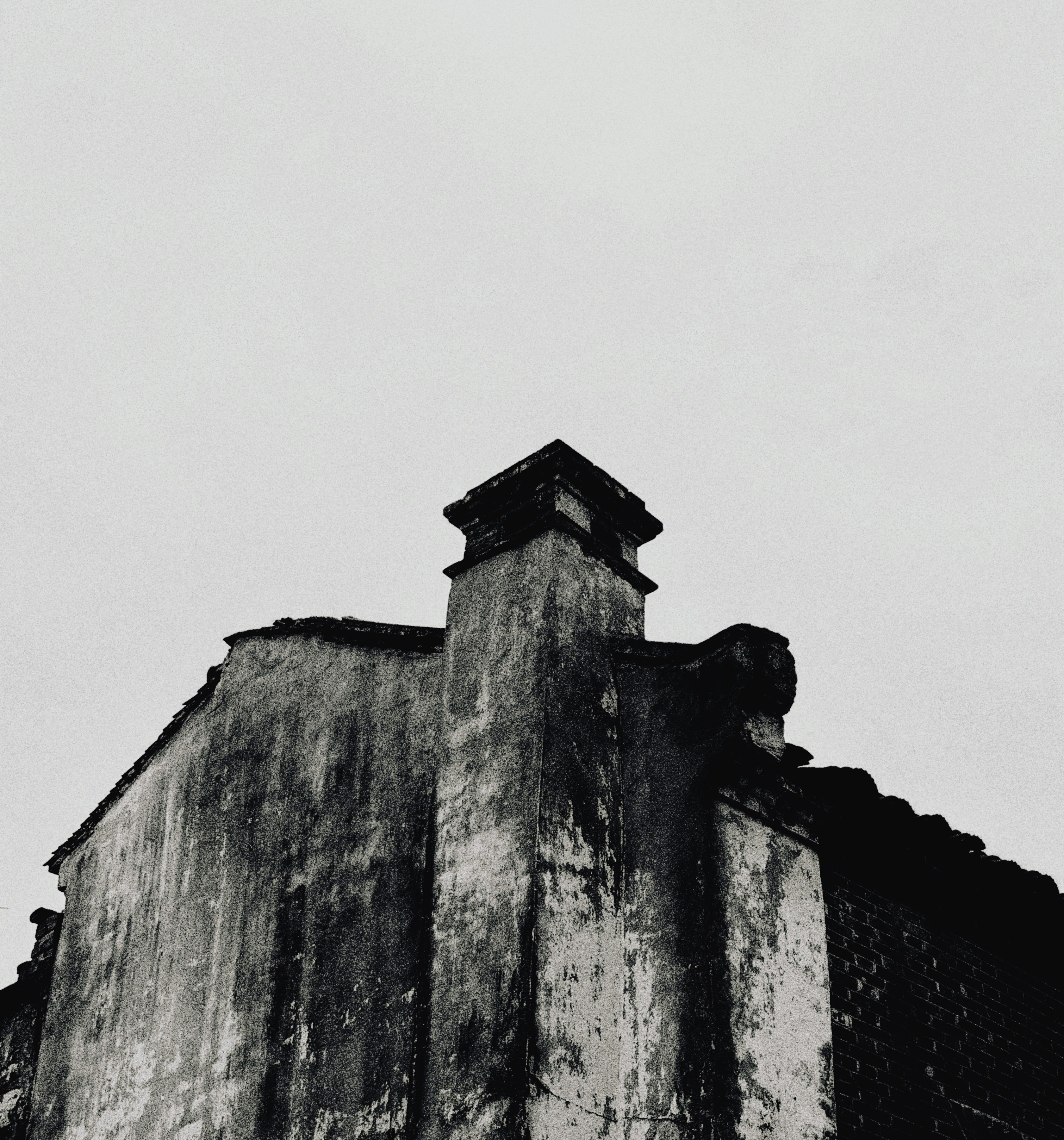 Old weathered building with a chimney against sky