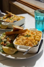 Two servings of macaroni and cheese with salad.