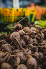 Freshly harvested beets piled at a market stall.