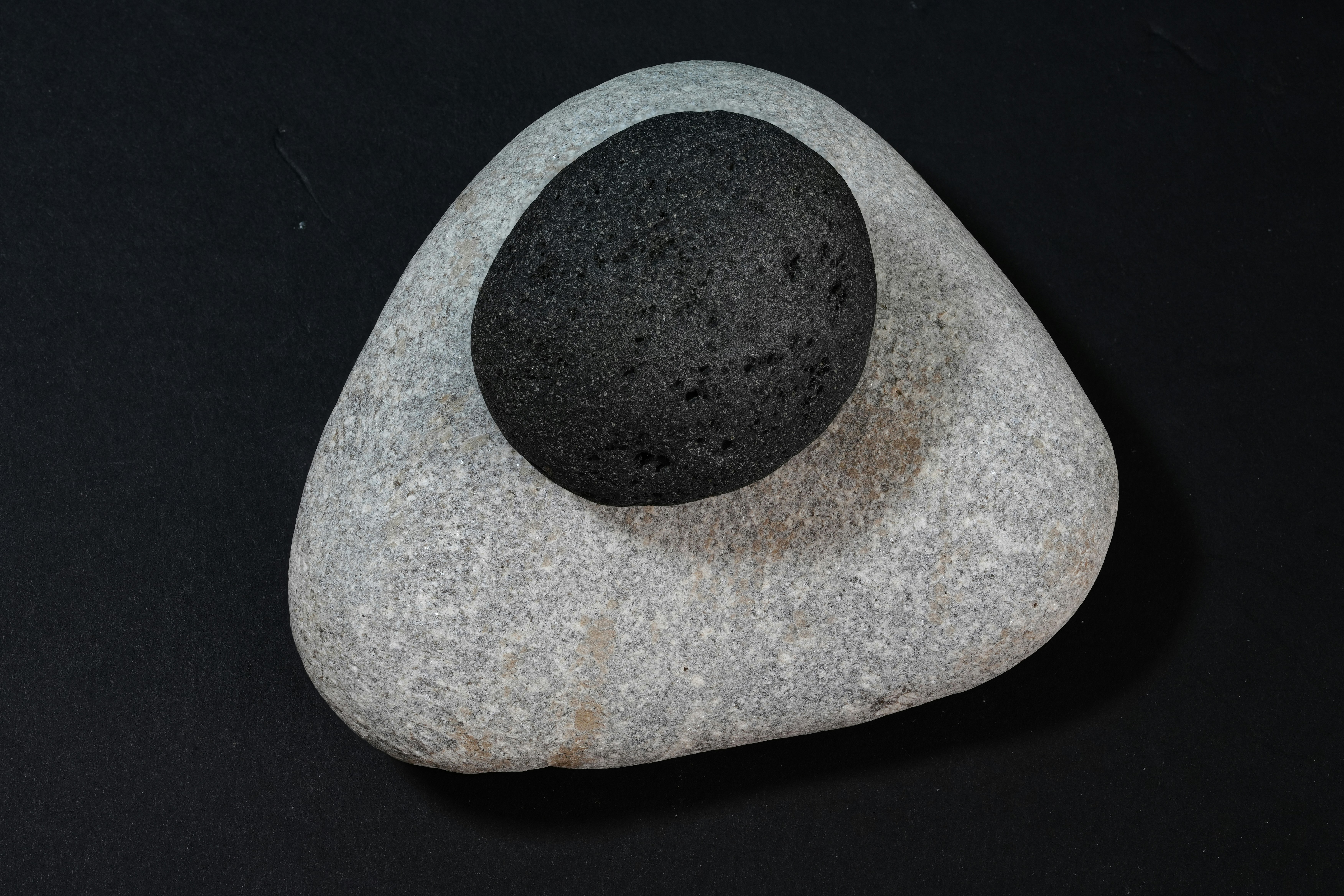 Two smooth stones, one dark and one light.