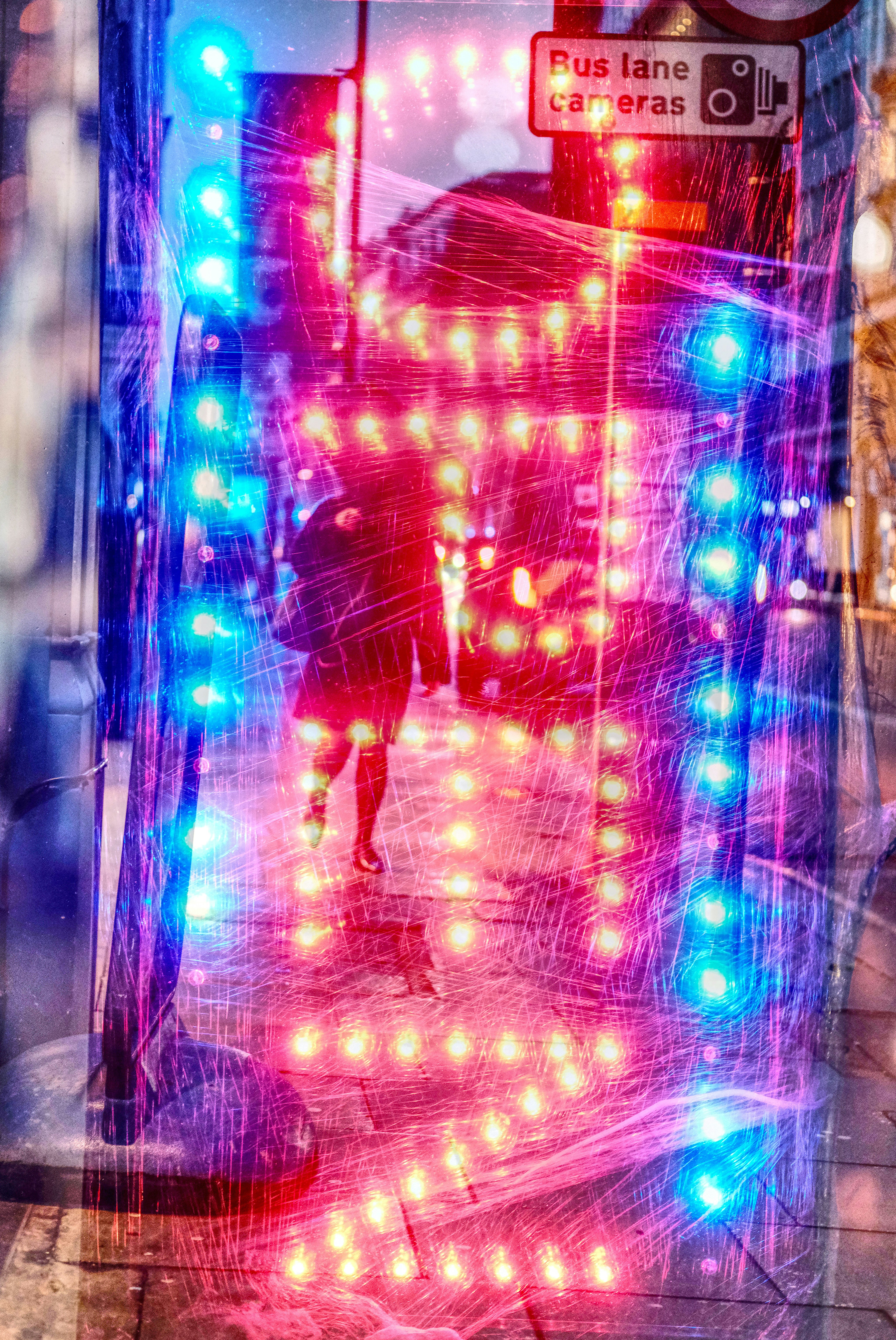 Woman walking past colorful city lights at night